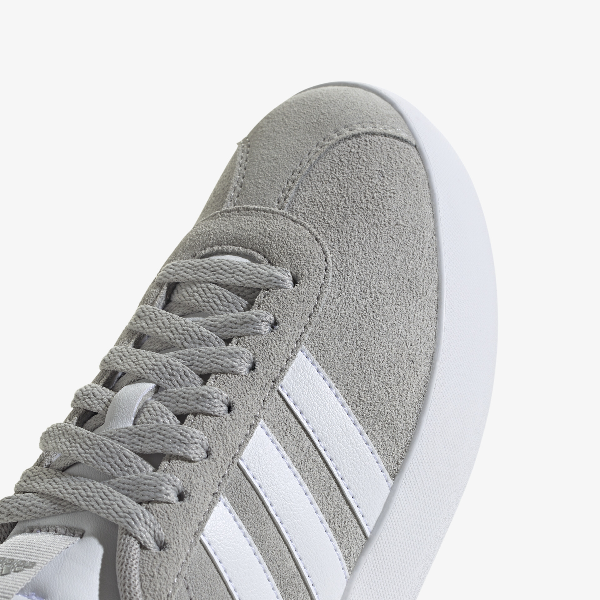 Detailaufnahme grauer Sneaker mit weißem Streifen und stabiler Schnürung, bequem und atmungsaktiv