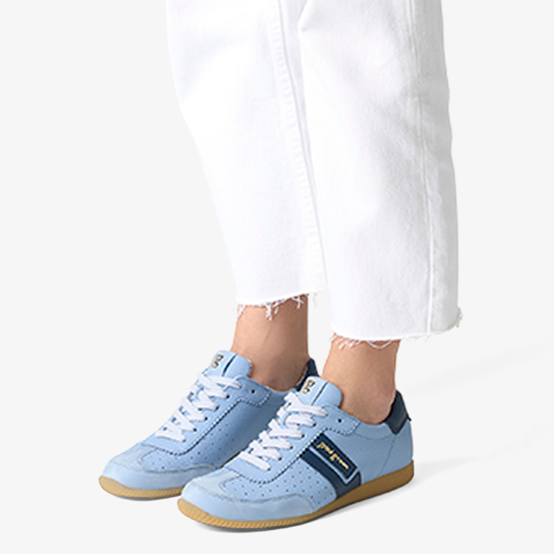 Blaue Sneaker mit sportlichem Design und bequemer Sohle, modisch getragen zu weißen Hosen.