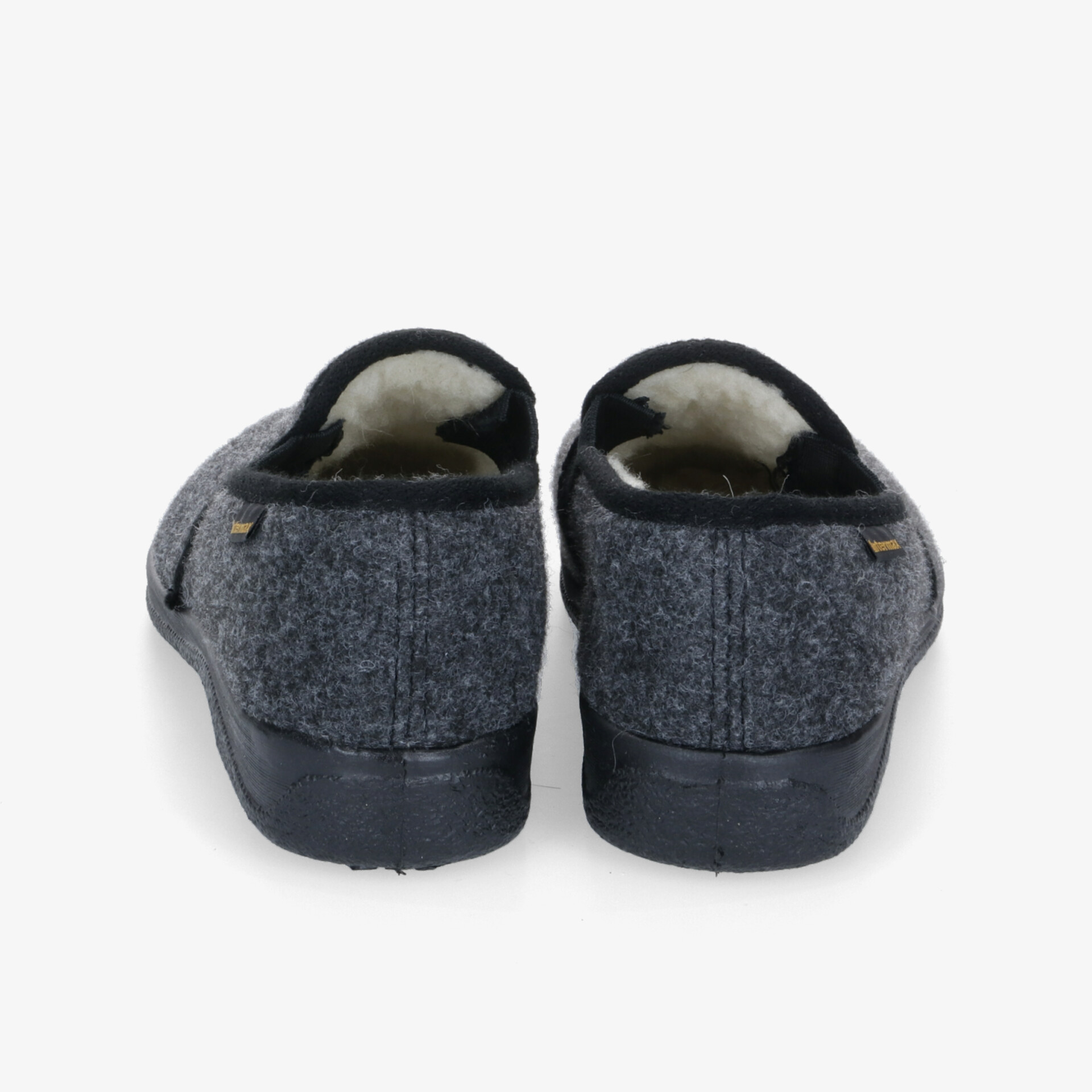 Komfortable Hausschuhe aus Filz mit weichem Futter, rutschfester Sohle und dunklem Design für gemütliche Stunden.