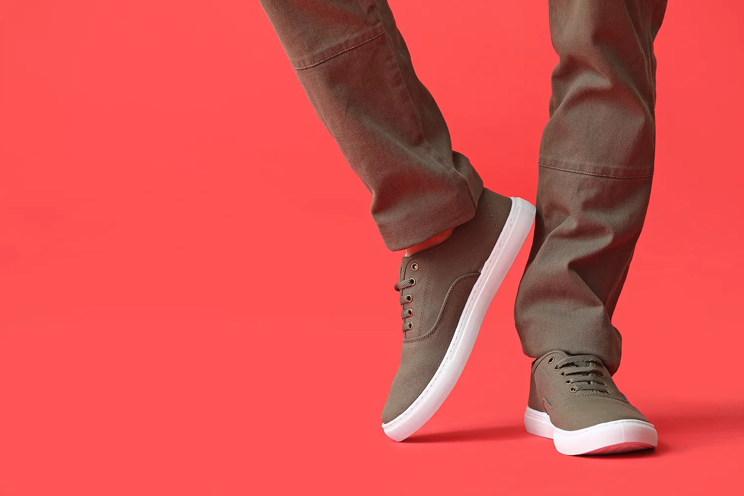 Männer tragen braune Halbschuhe mit weißen Sohlen vor rotem Hintergrund