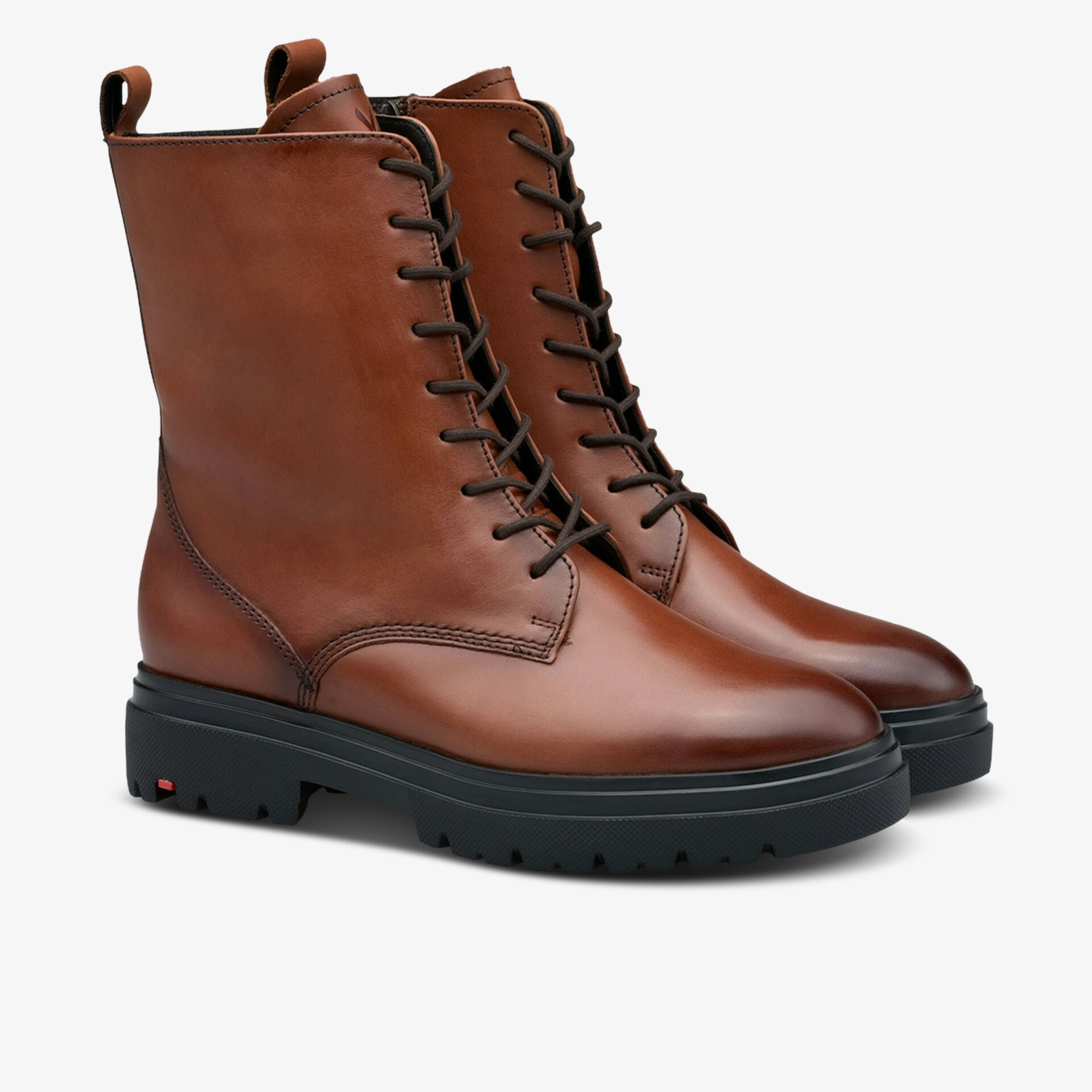 Braune Lederstiefel mit robuster schwarzer Gummisohle und modischer Schnürung in schräger Frontansicht