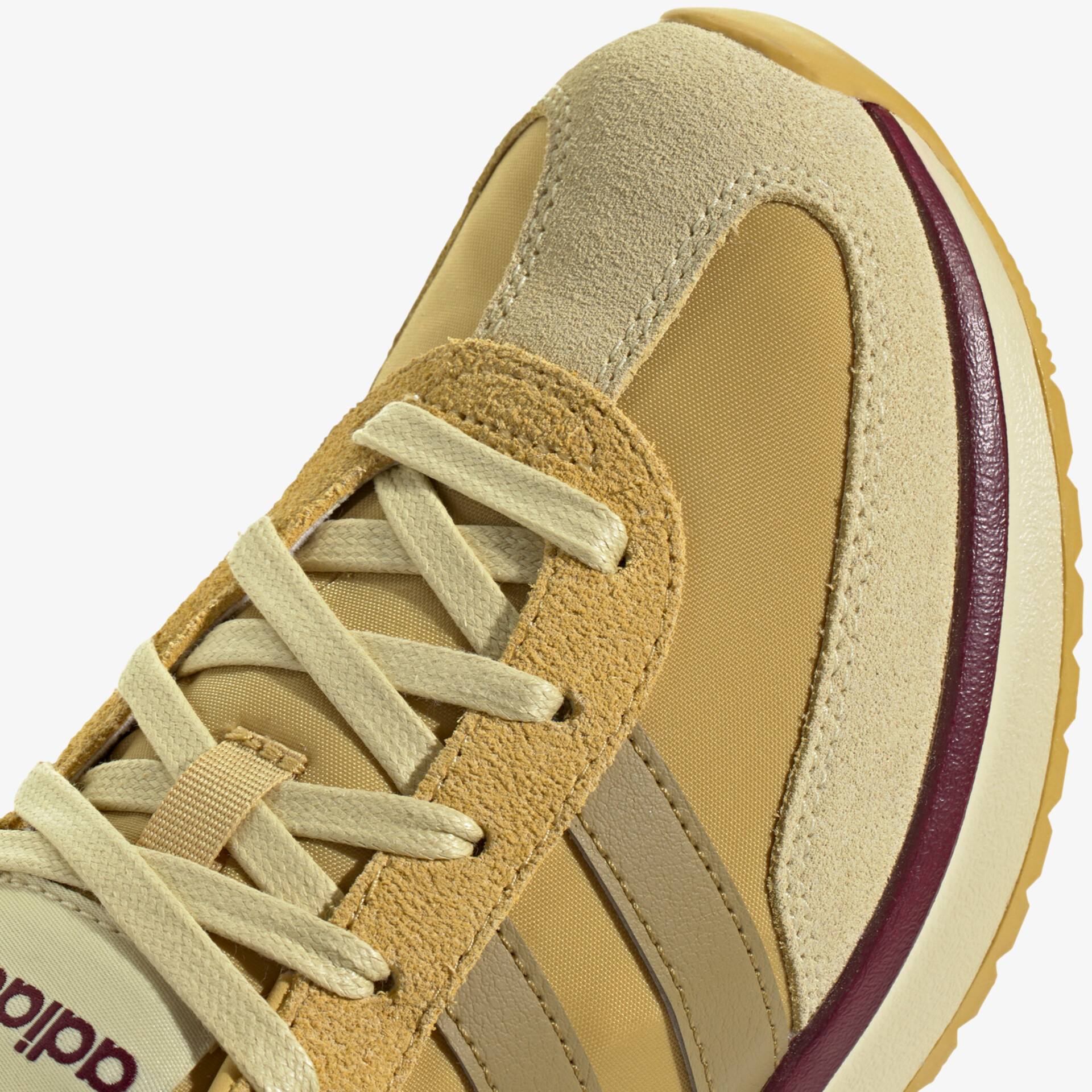 Detailaufnahme eines beigen Sneakers mit Schnürung und verschiedenen Materialien in modernem Design
