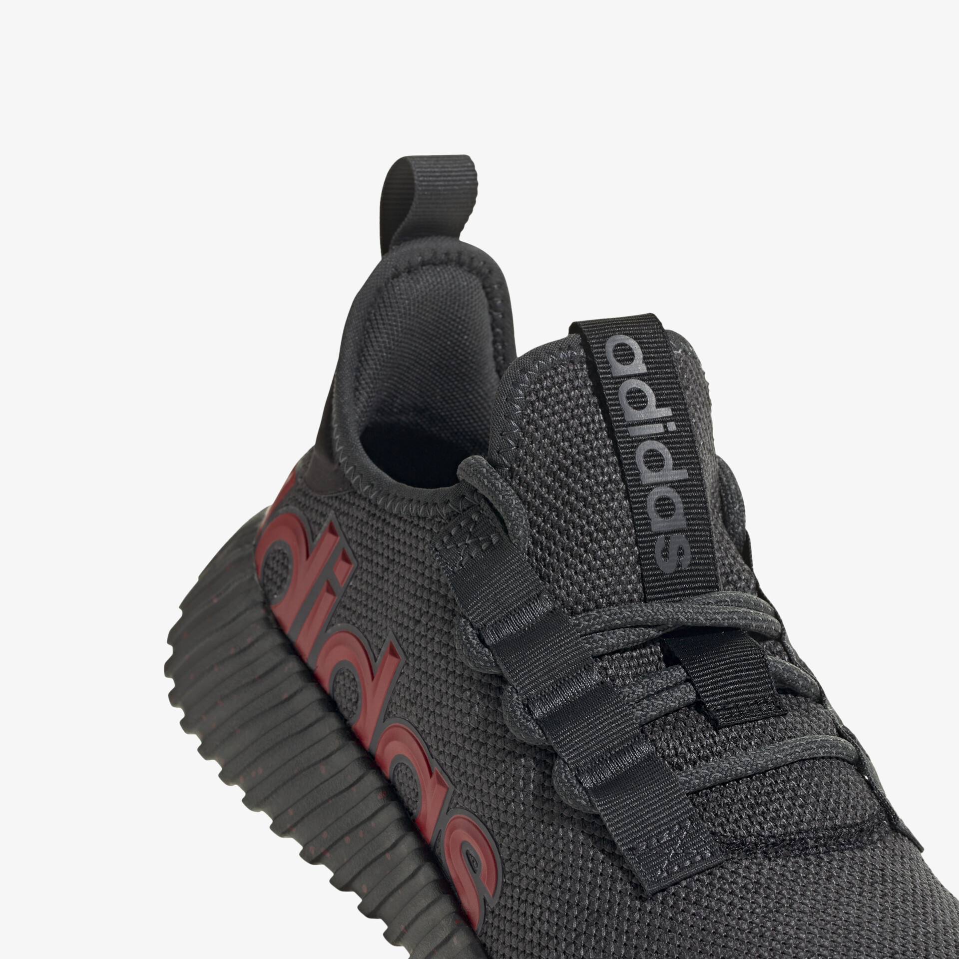 Detailansicht eines schwarzen Adidas Sportschuhs mit markantem Logo und flexibler Schnürung