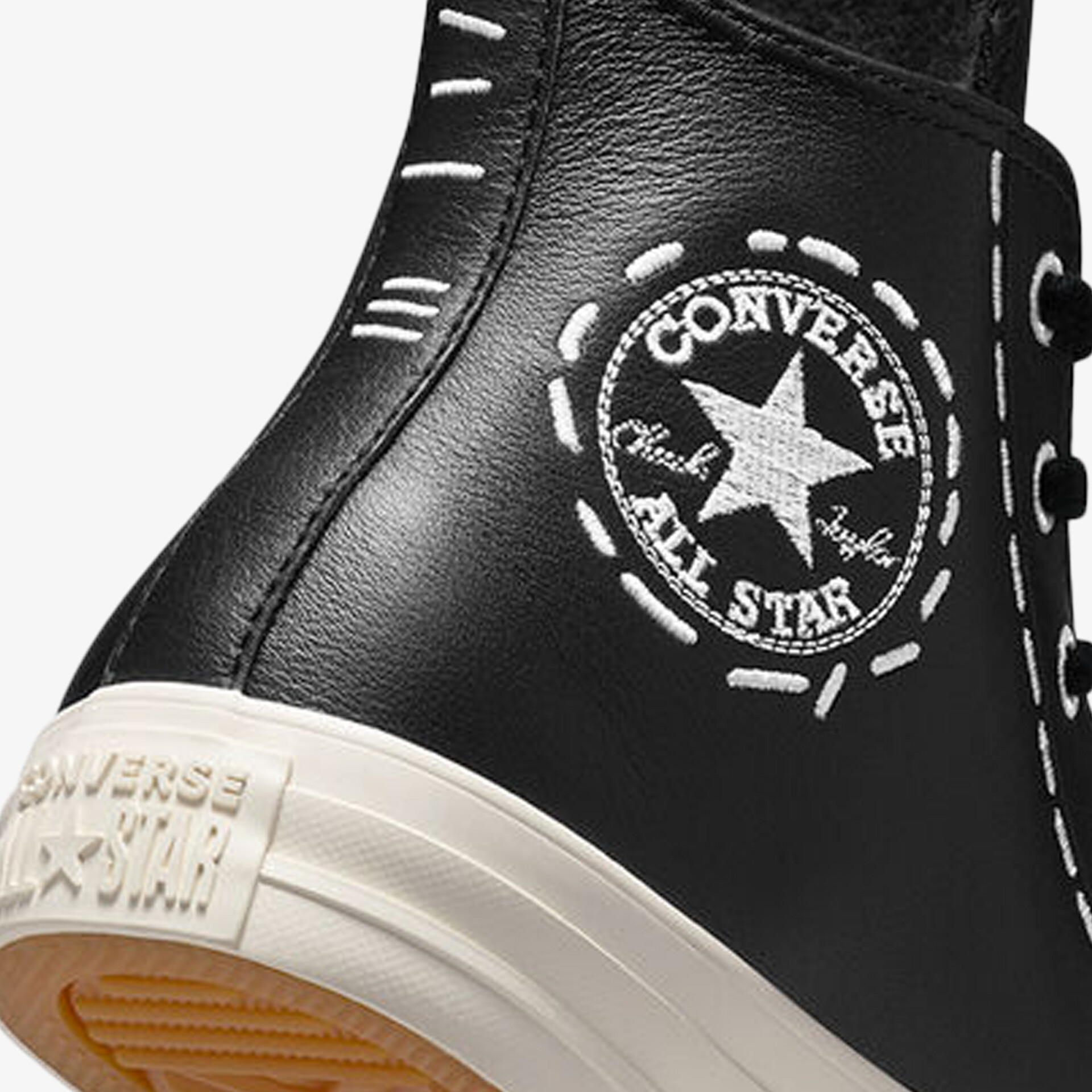 Detailaufnahme eines schwarzen Converse Lederschuhs mit weißem Stern-Logo und robuster Sohle