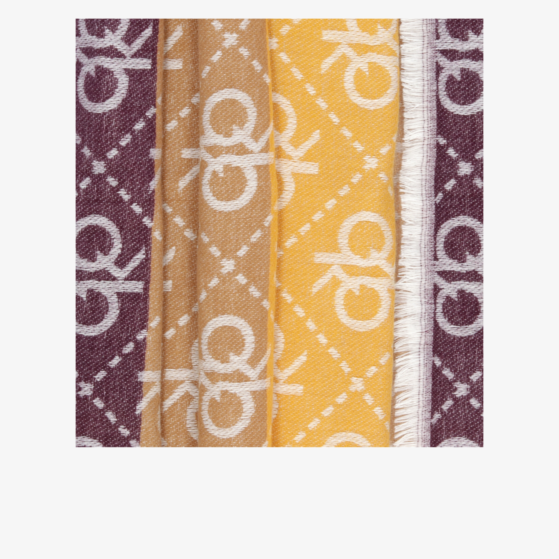 Detailaufnahme eines Stoffmusters in braun und gelb mit sichtbaren Nähten und auffälligem Logo-Design