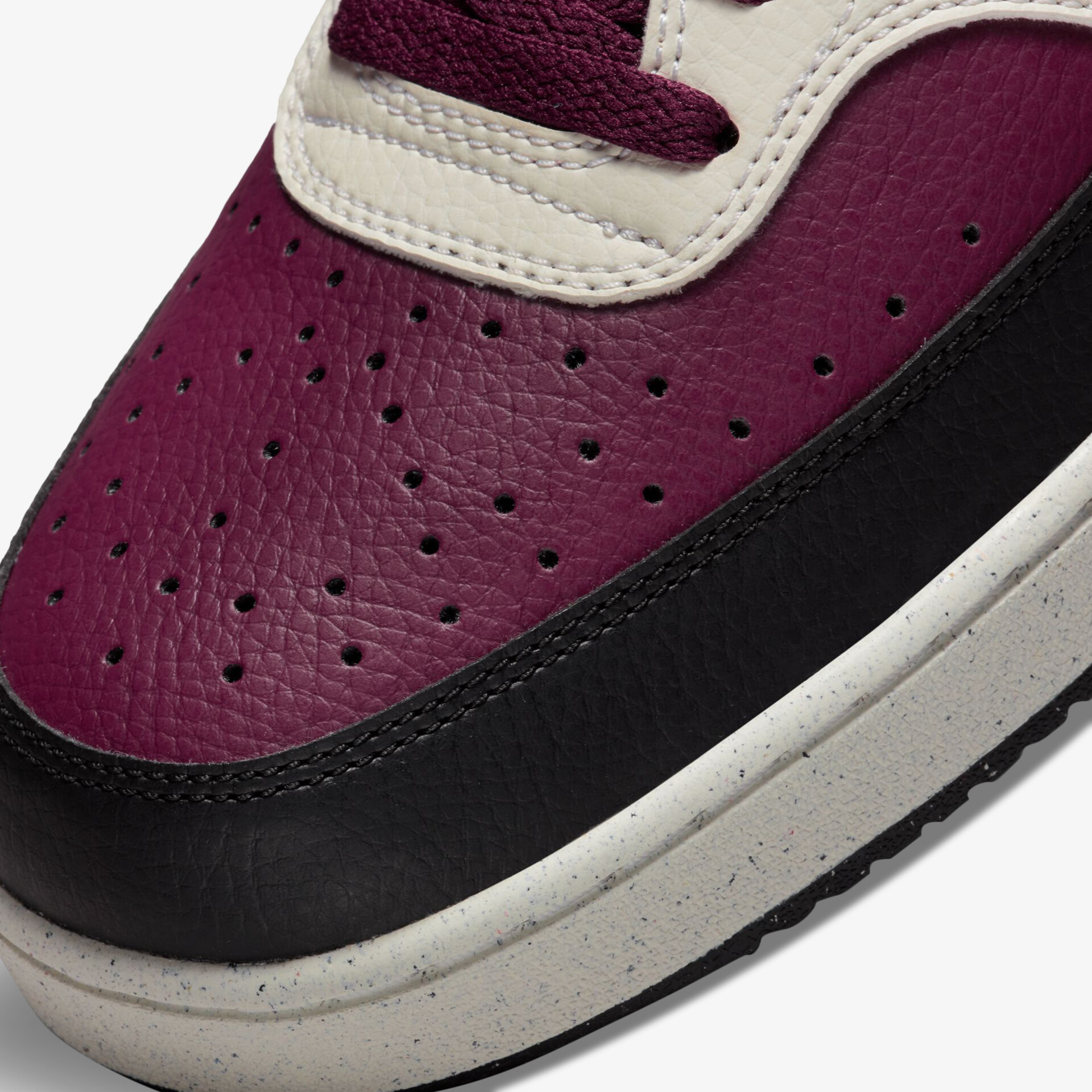 Leder-Sneaker in Lila mit perforiertem Design und kontrastreichen Akzenten in Weiß und Schwarz.