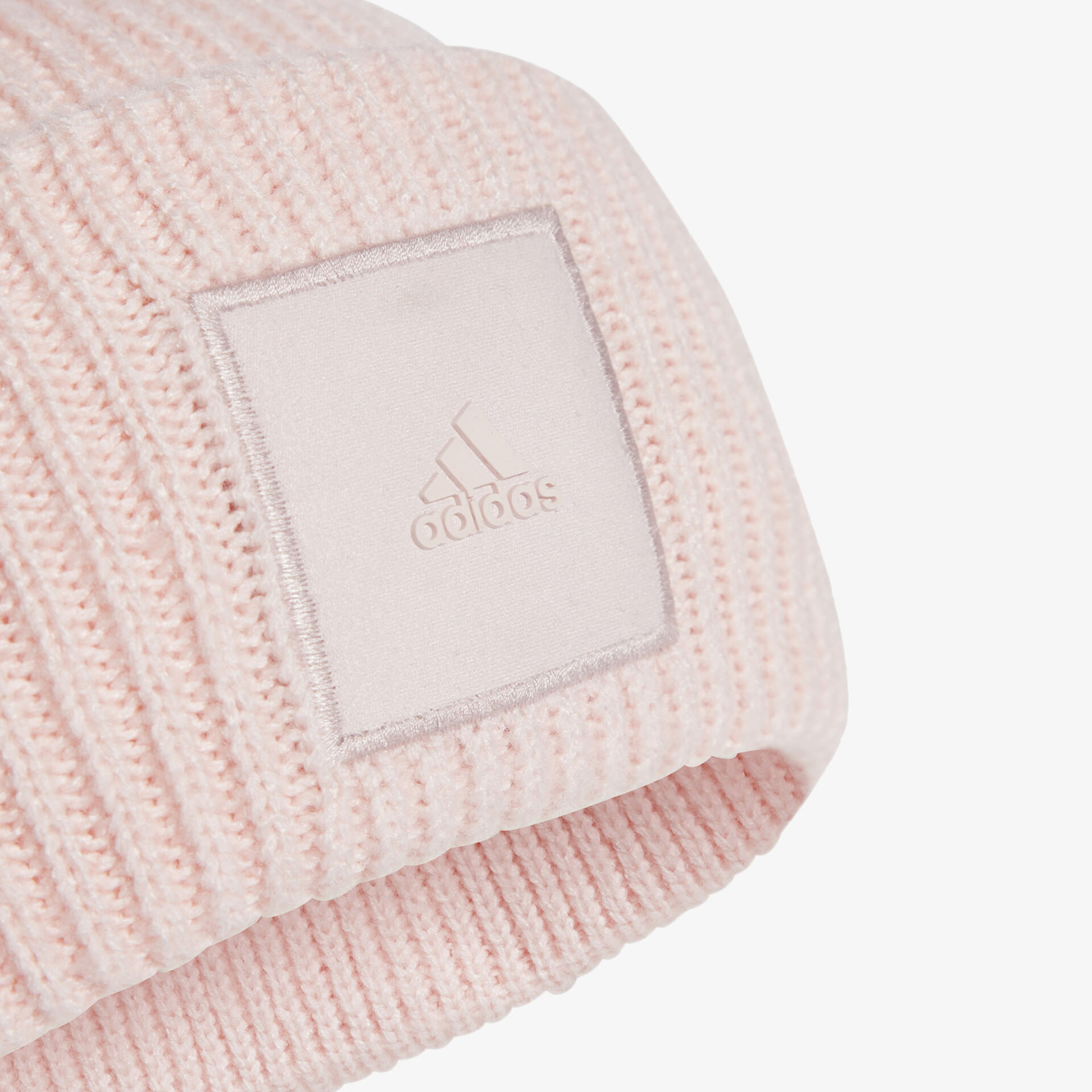 Detailansicht einer rosa Strickmütze mit eingearbeitetem adidas Logo-Patch aus weichem, warmem Material