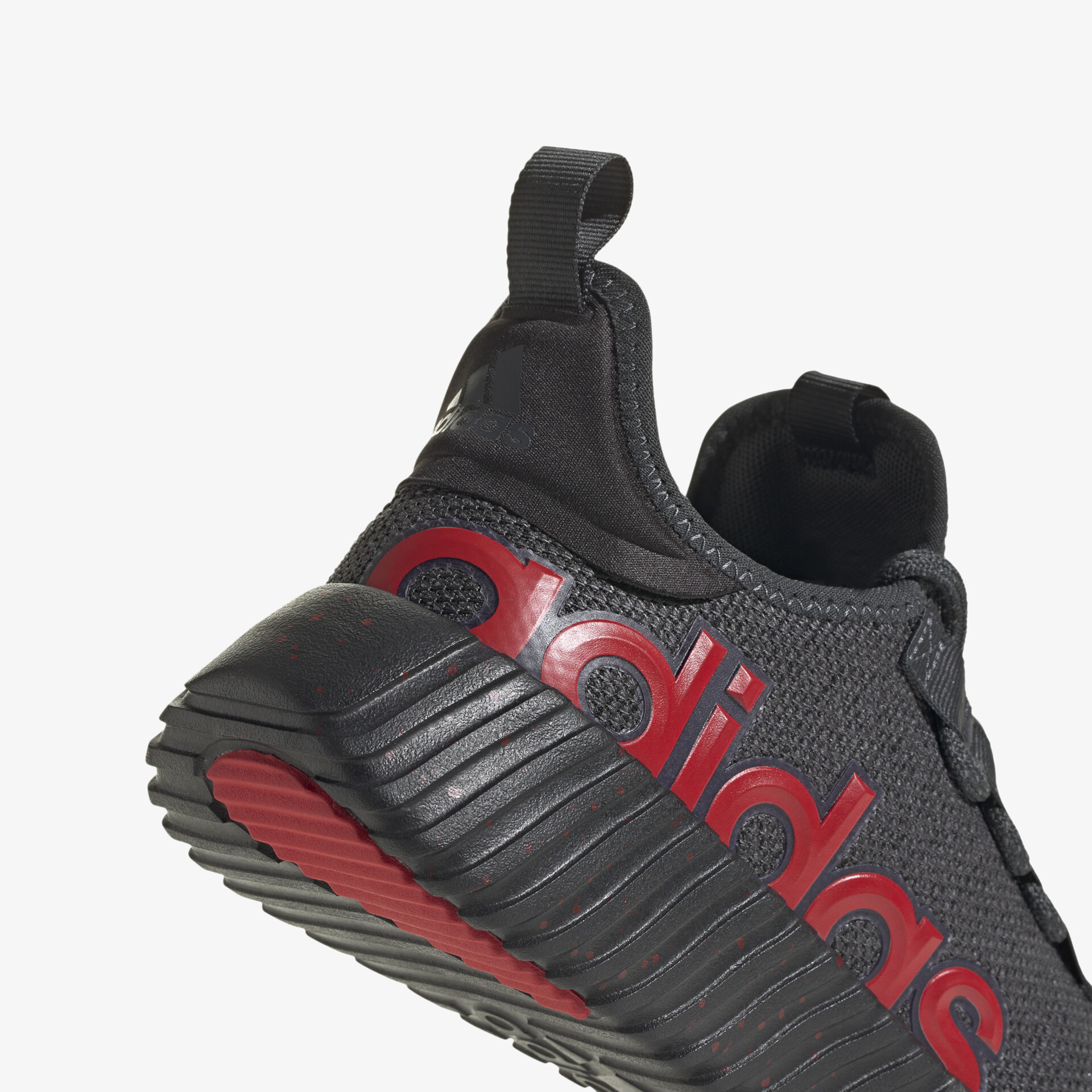 Detailaufnahme eines schwarzen Adidas Sneakers mit rotem Logo und flexibler, profilierter Sohle