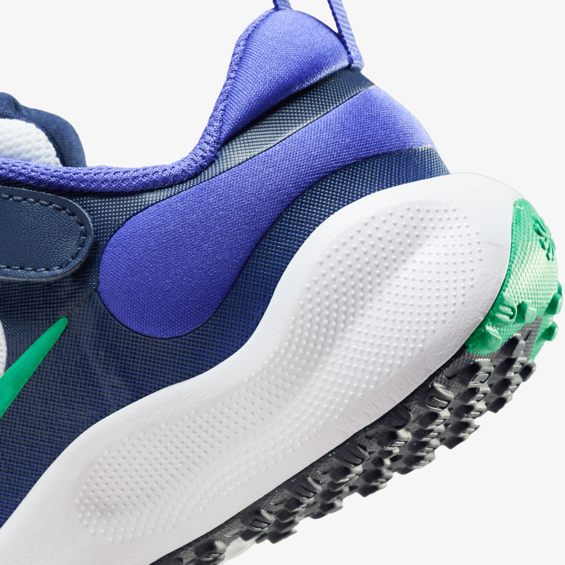 Detailansicht eines blauen Sportschuhs mit grüner Akzentfarbe und dämpfender, rutschfester weißer Sohle