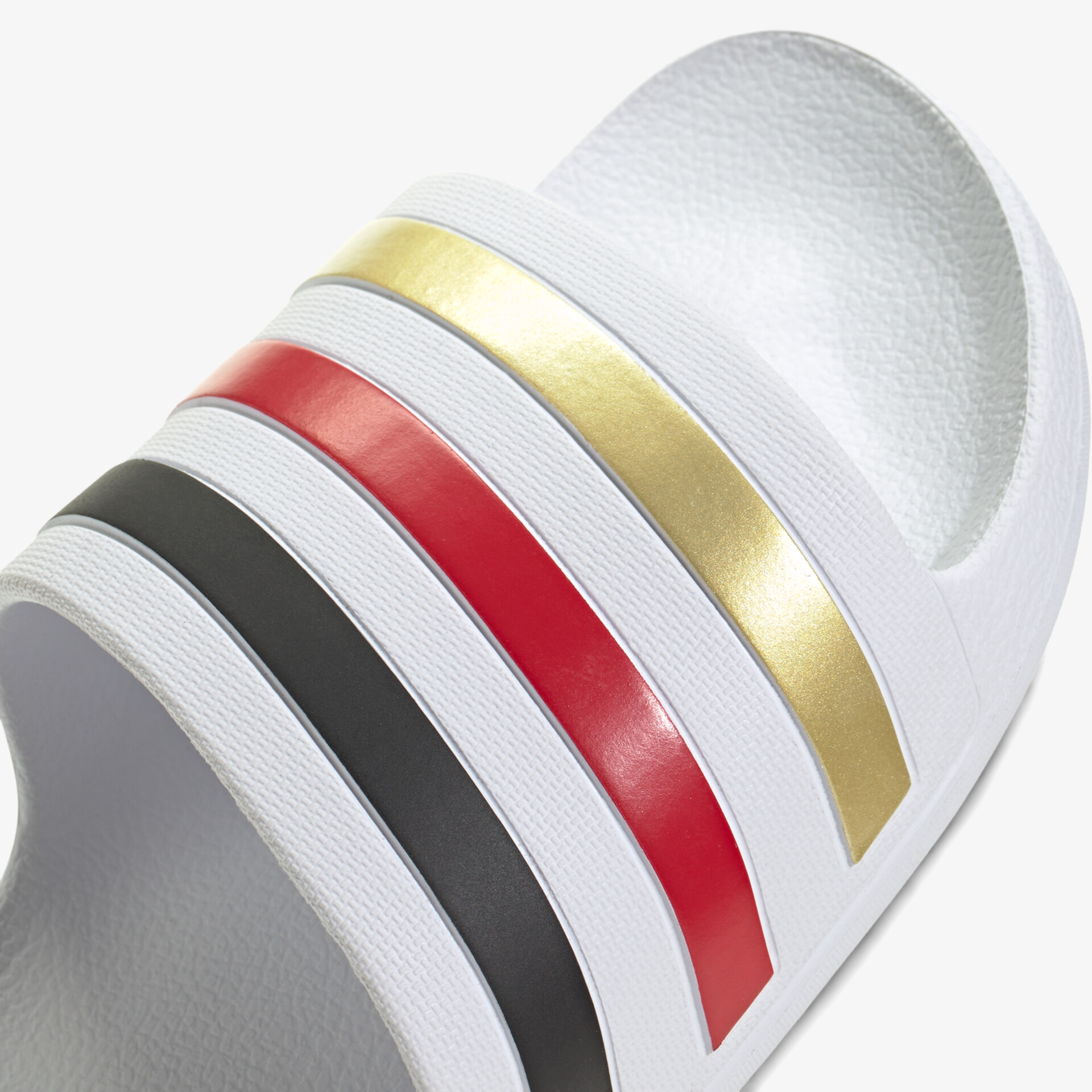 Weißer Schuh mit breiten goldfarbenen, roten und schwarzen Riemen, modernes Design, komfortabel und strapazierfähig