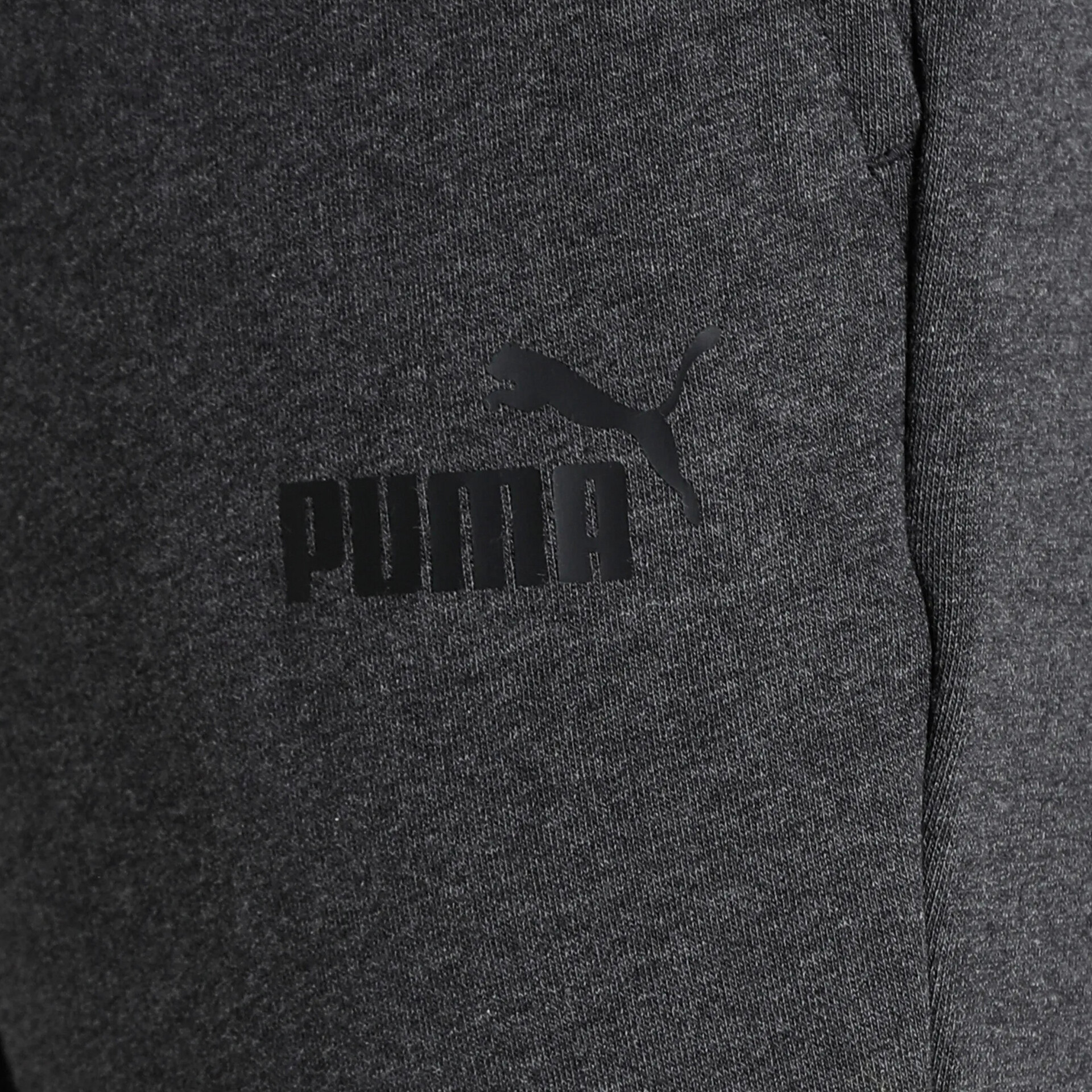 Dunkelgrauer Stoff mit schwarzem Puma Logo in Detailaufnahme, zeigt hochwertige Textur und Verarbeitung