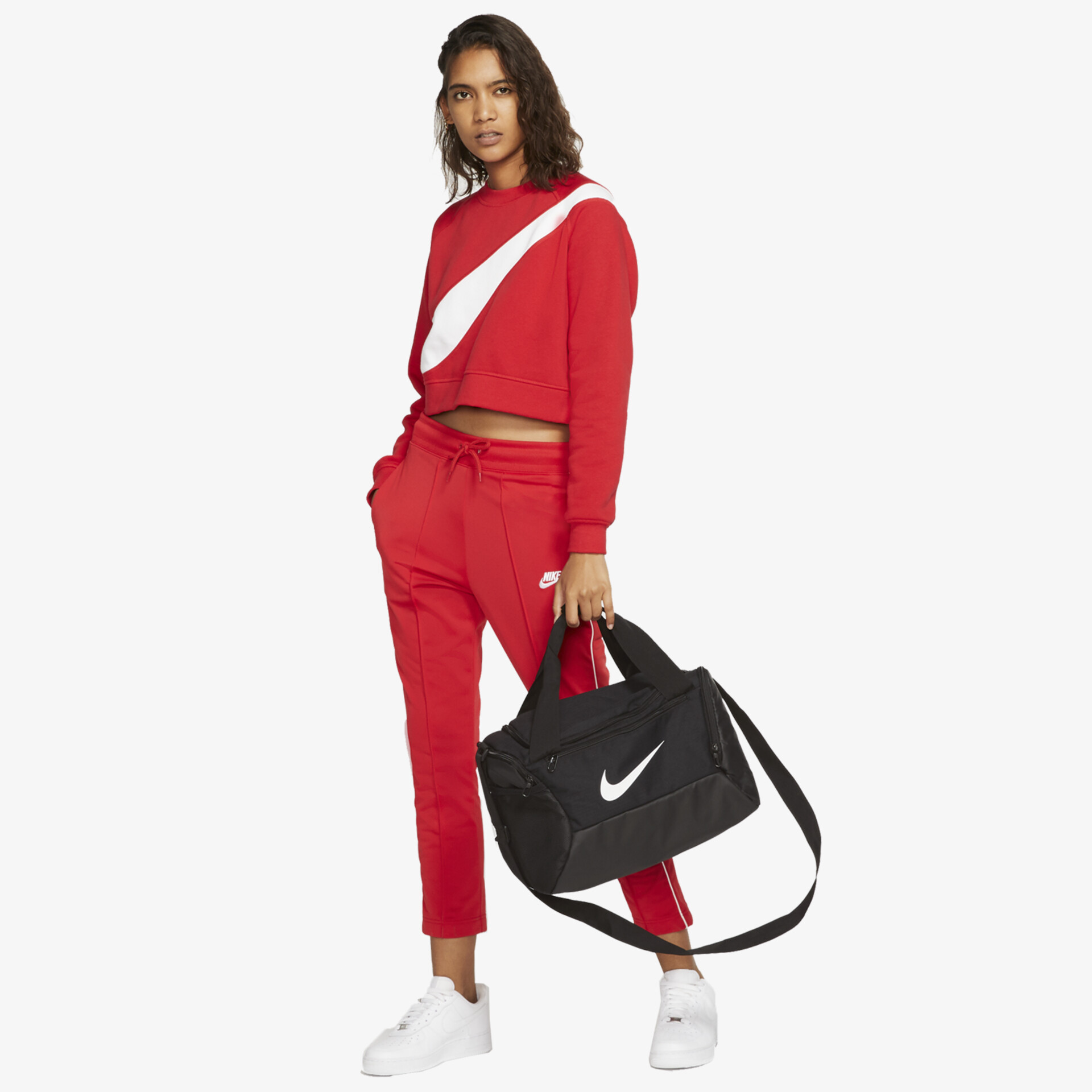 Stilvolles rotes Set mit sportlichem Design, kombiniert mit schwarzer Tasche und weißen Sneakern.