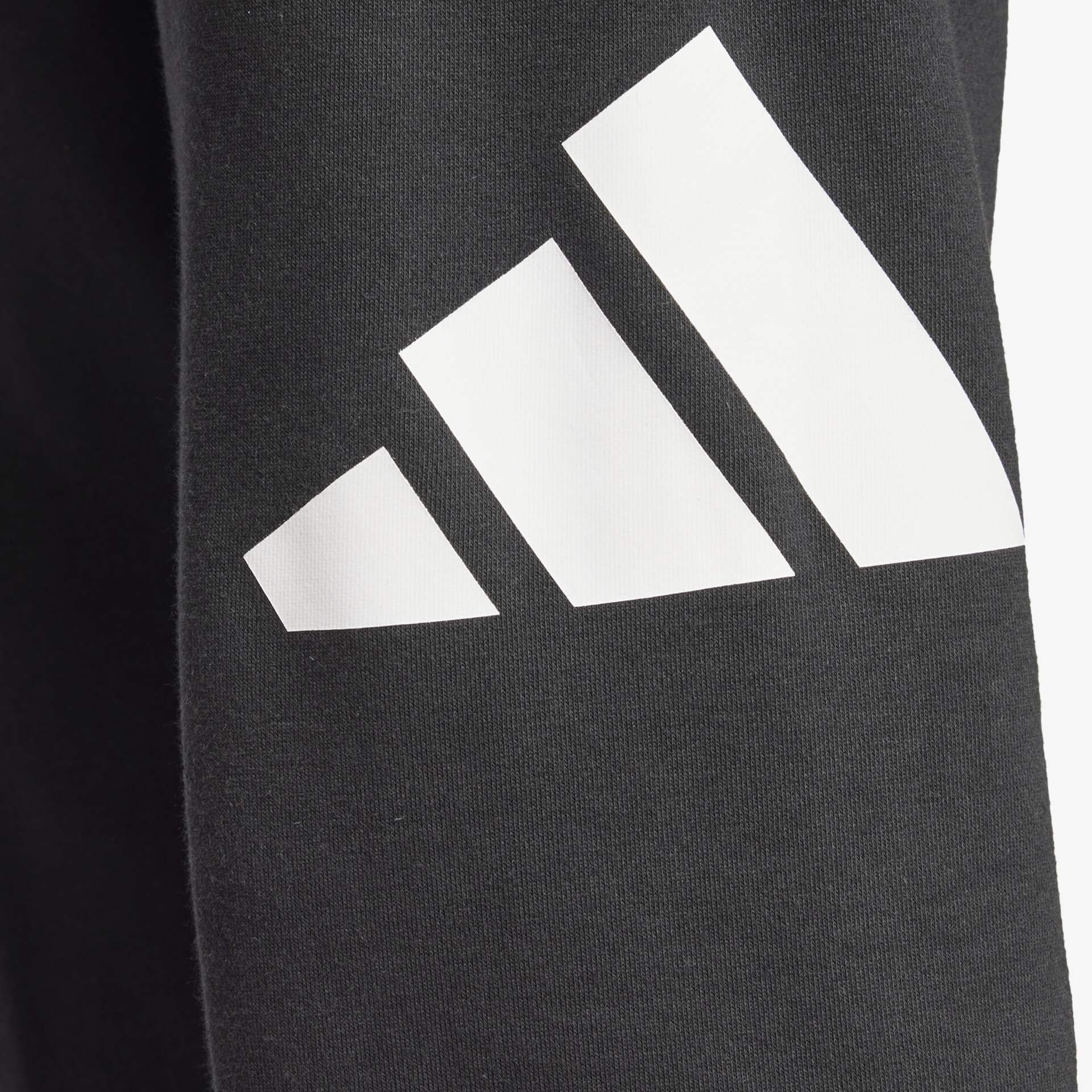 Detailaufnahme des Adidas Logos in Schwarz-Weiß auf hochwertigem Stoff mit klaren Linien und modernem Look