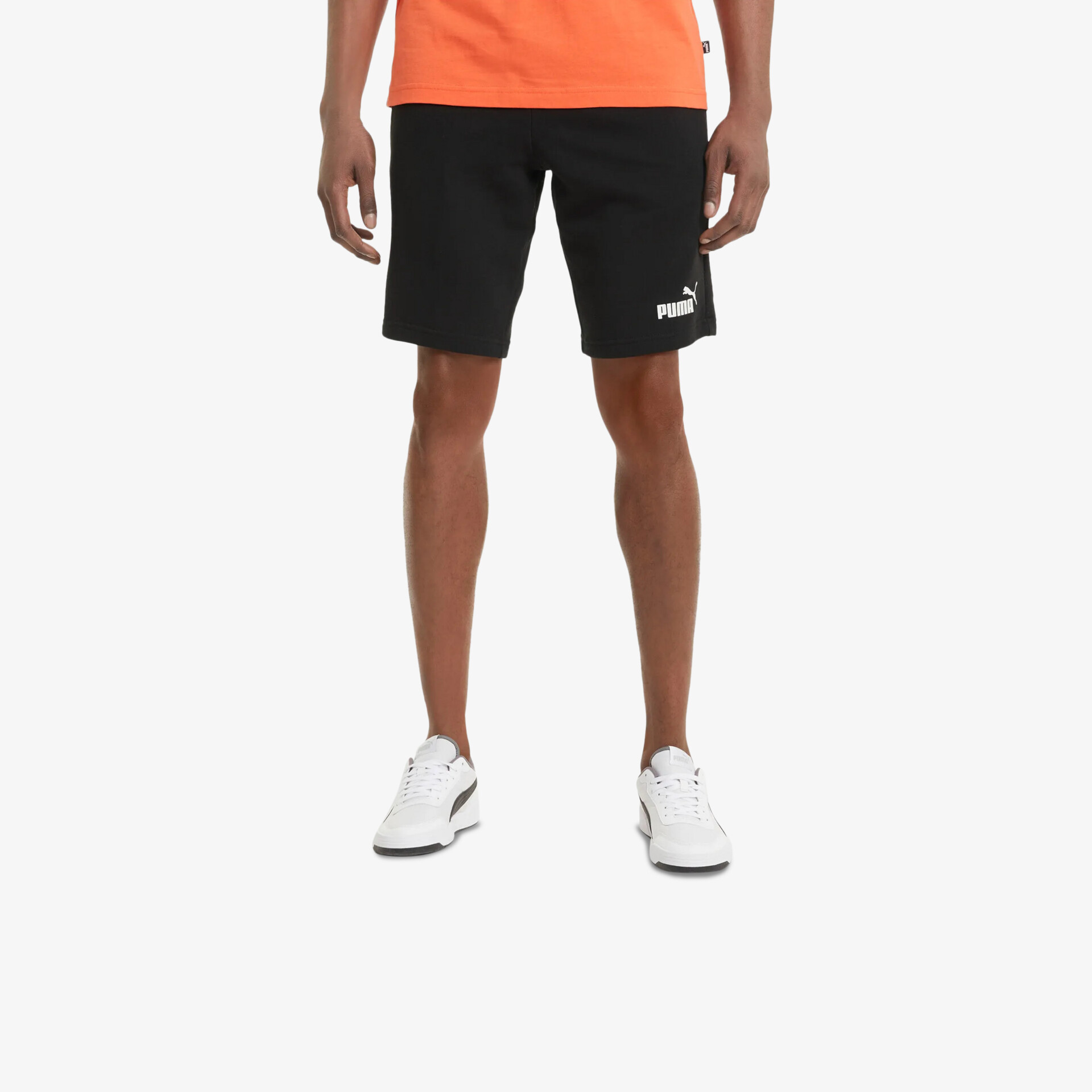 Person trägt weiße Sneaker und schwarze sportliche Shorts, bequem und stilvoll für Alltag und Aktivitäten
