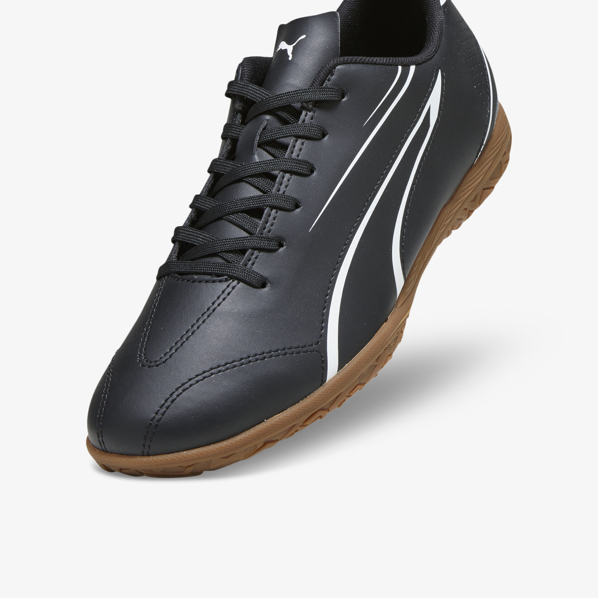 Sportlicher schwarzer Sneaker mit brauner Sohle und weißen Linien in schräger Vorderansicht