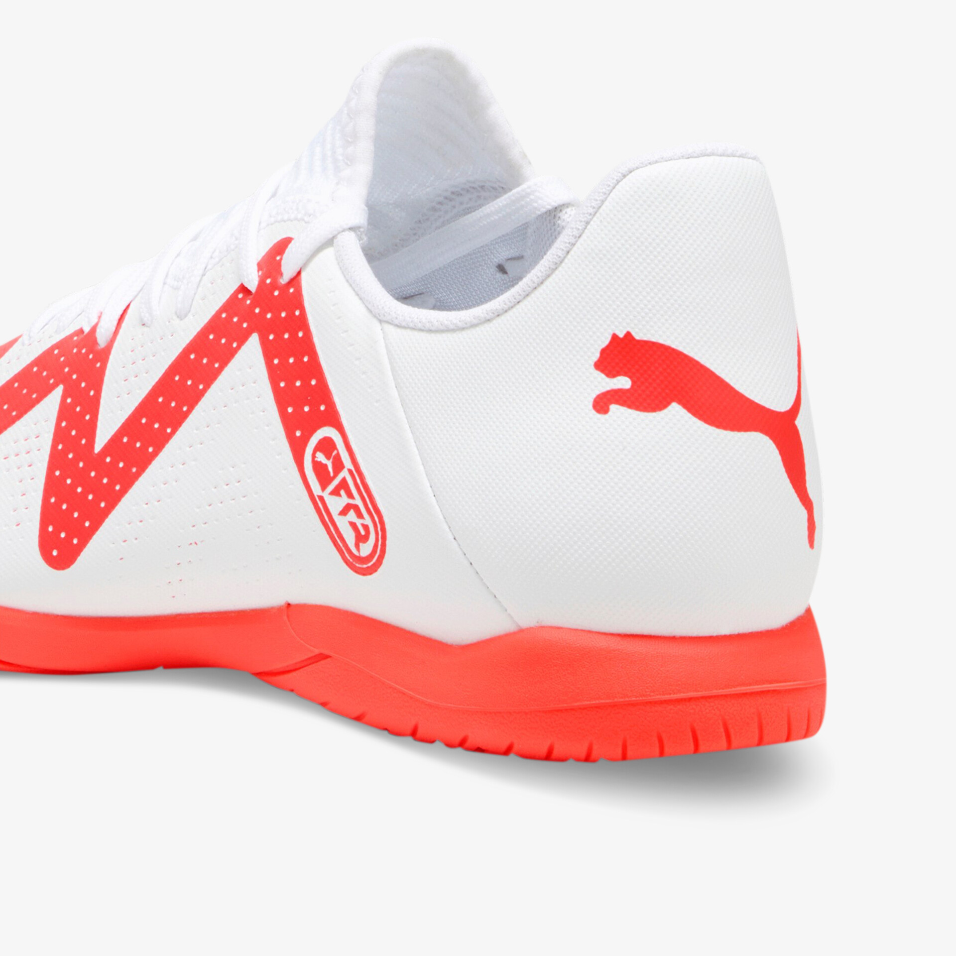 Moderner Hallenschuh in Weiß mit rotem Akzent und griffiger Sohle für optimalen Halt und Komfort.
