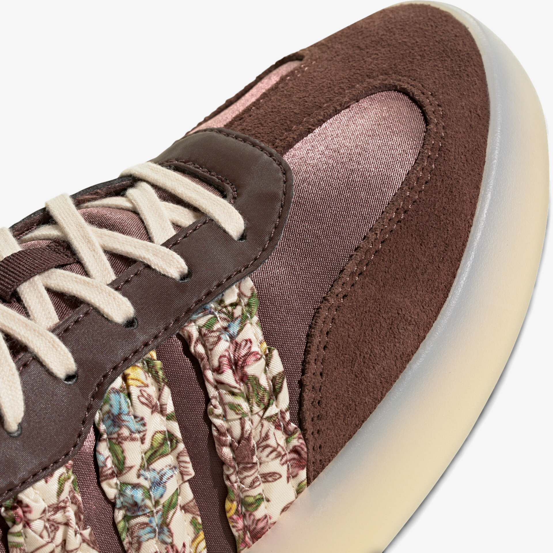 Detailansicht Sneaker mit braunem Veloursleder und floralem Muster, stylische Schnürung sichtbar