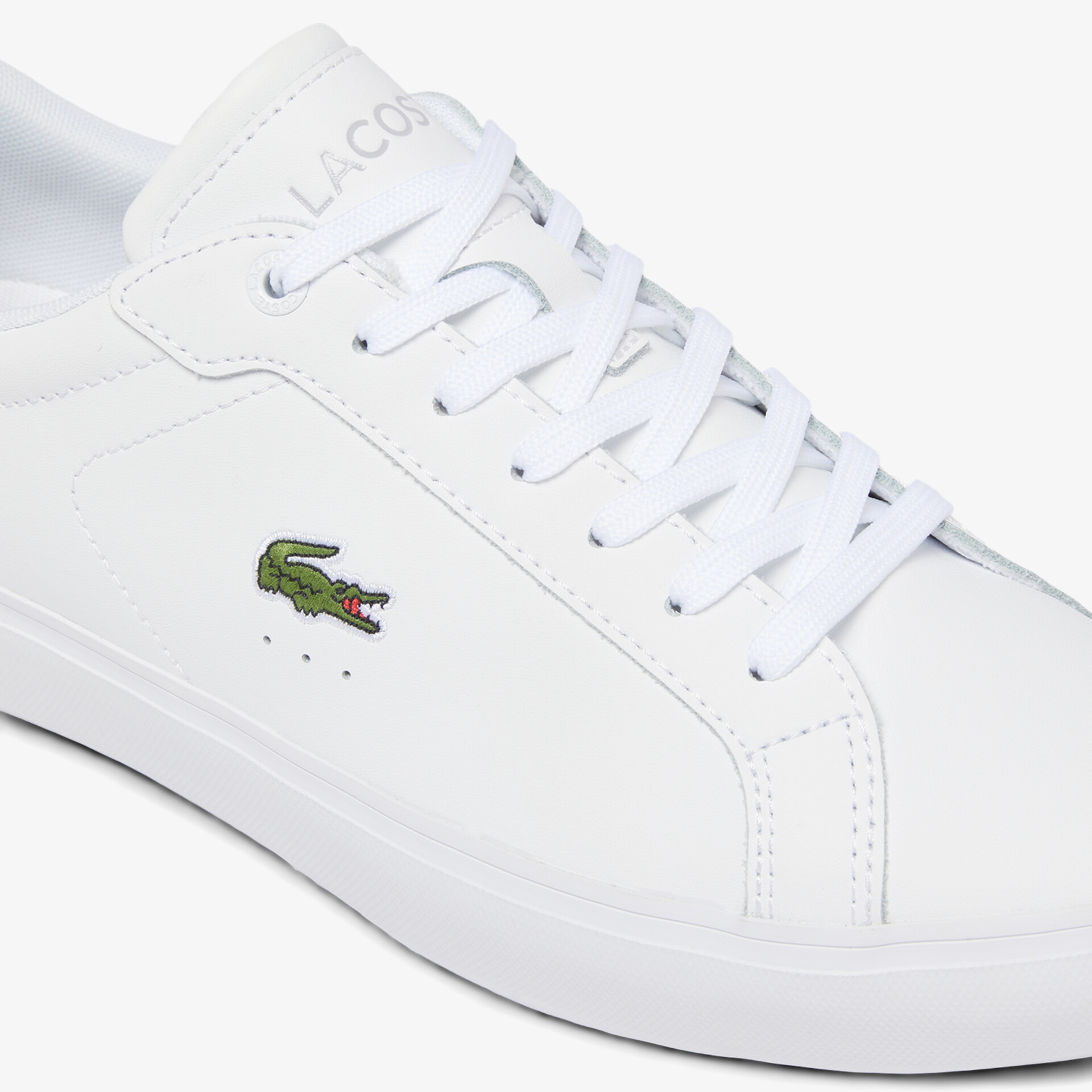 Weißer Leder Sneaker mit grünem Lacoste Krokodil-Logo und klassischer Schnürung in Frontansicht
