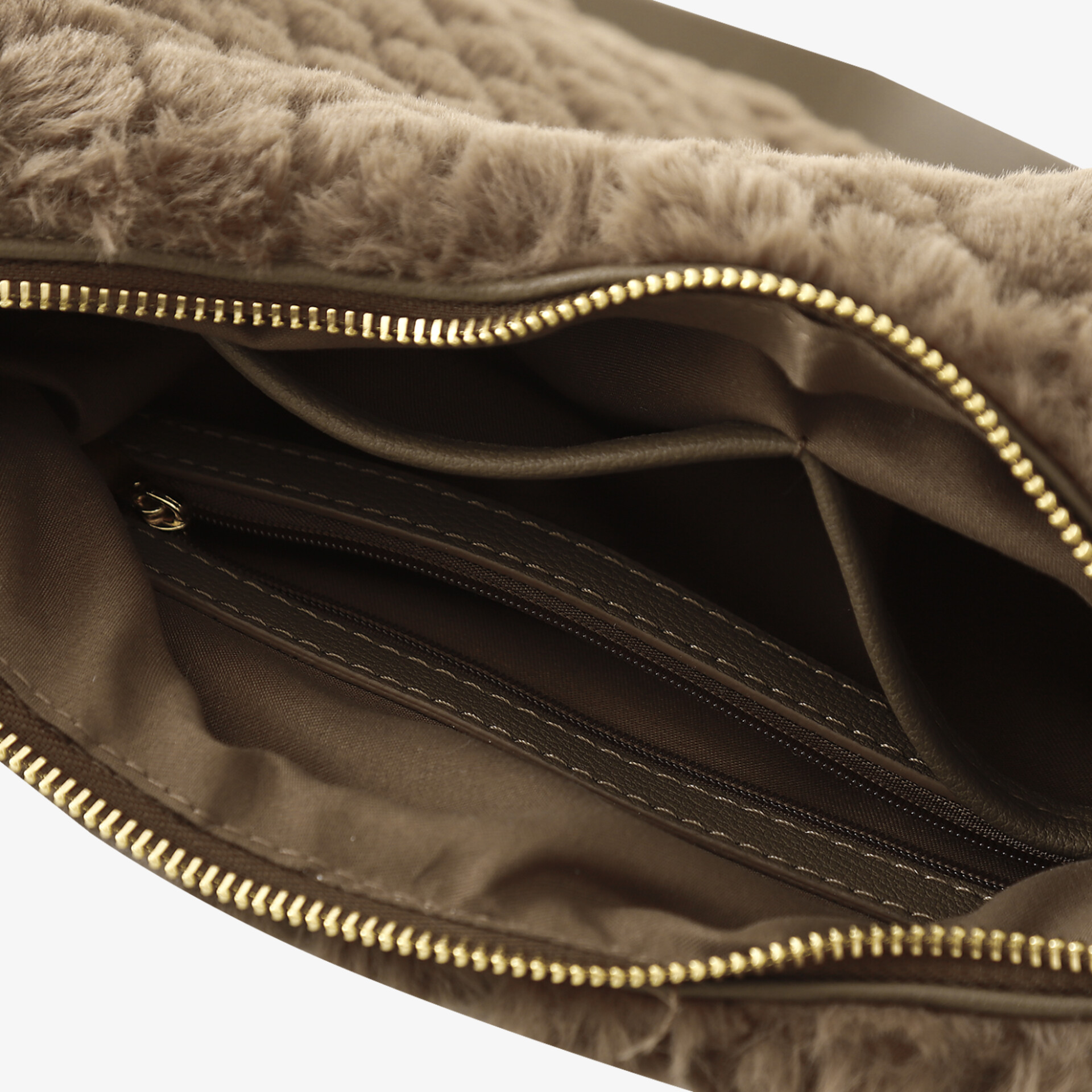 Detailaufnahme des Innenfachs eines Produkts mit Reißverschluss und weichem, kuscheligem Innenfutter