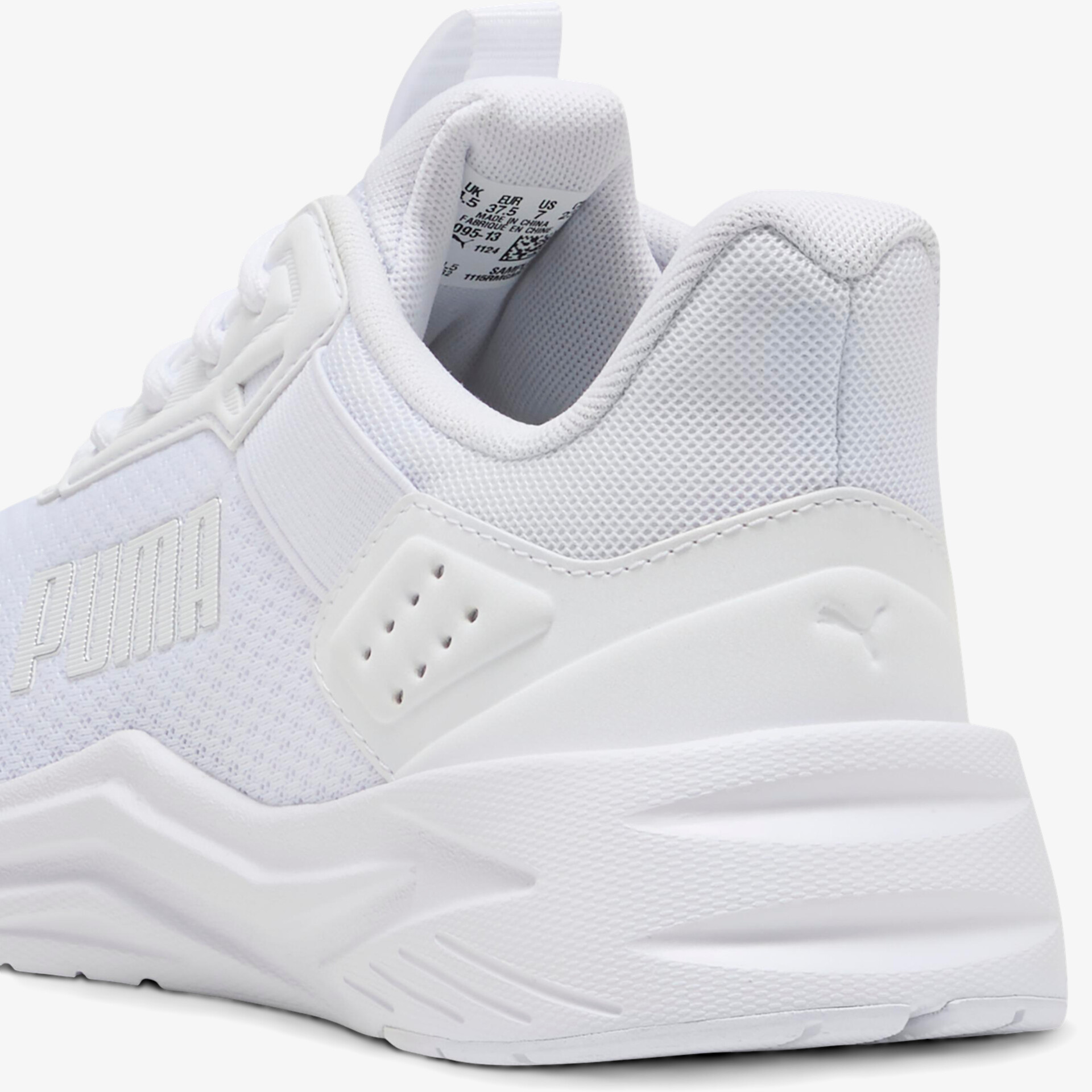 Moderner weißer Sneaker mit atmungsaktivem Mesh, bequemer Polsterung und rutschfester Sohle seitlich aufgenommen