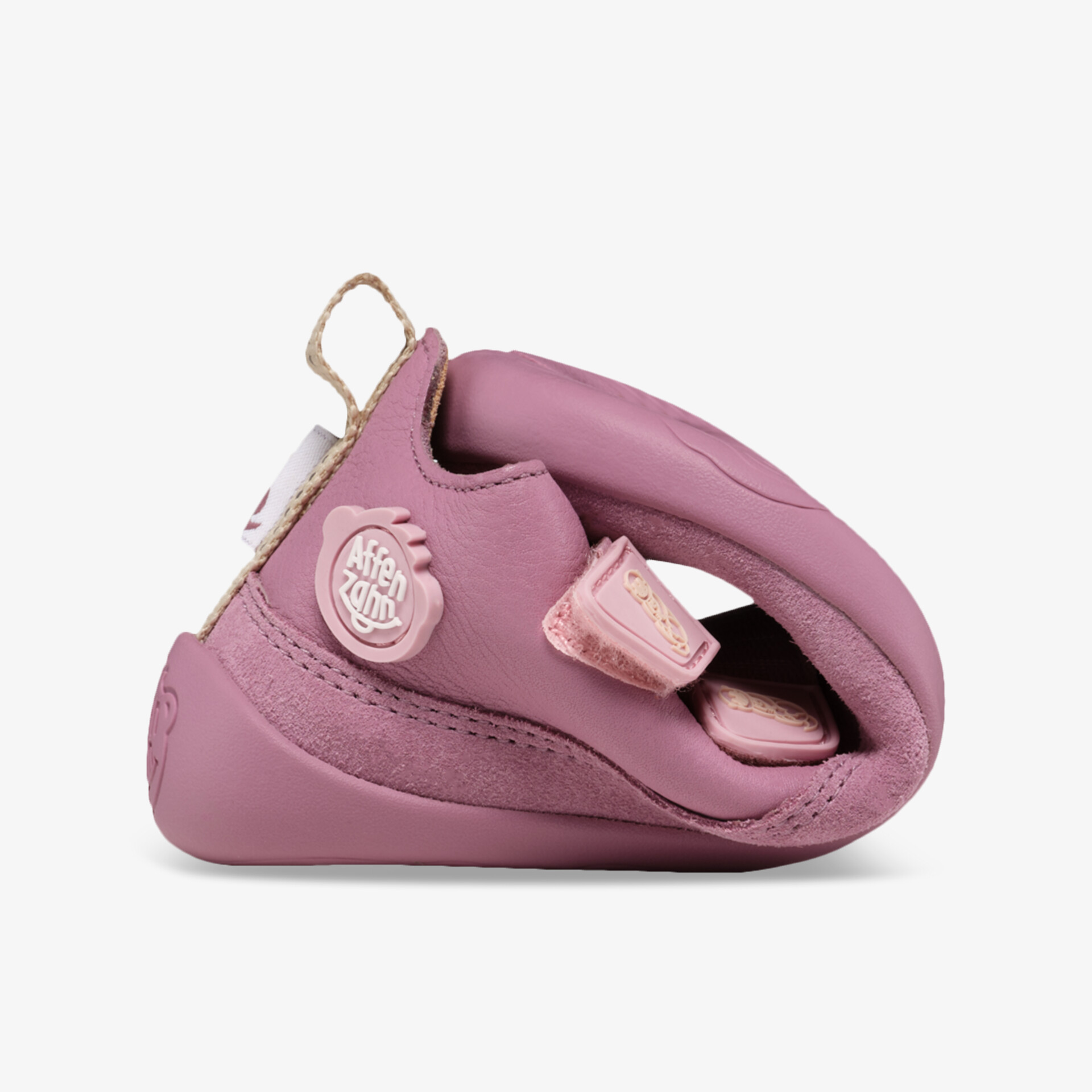 Flexibler rosafarbener Schuh, stark zusammengefaltet zur Demonstration der Biegsamkeit und Komfort