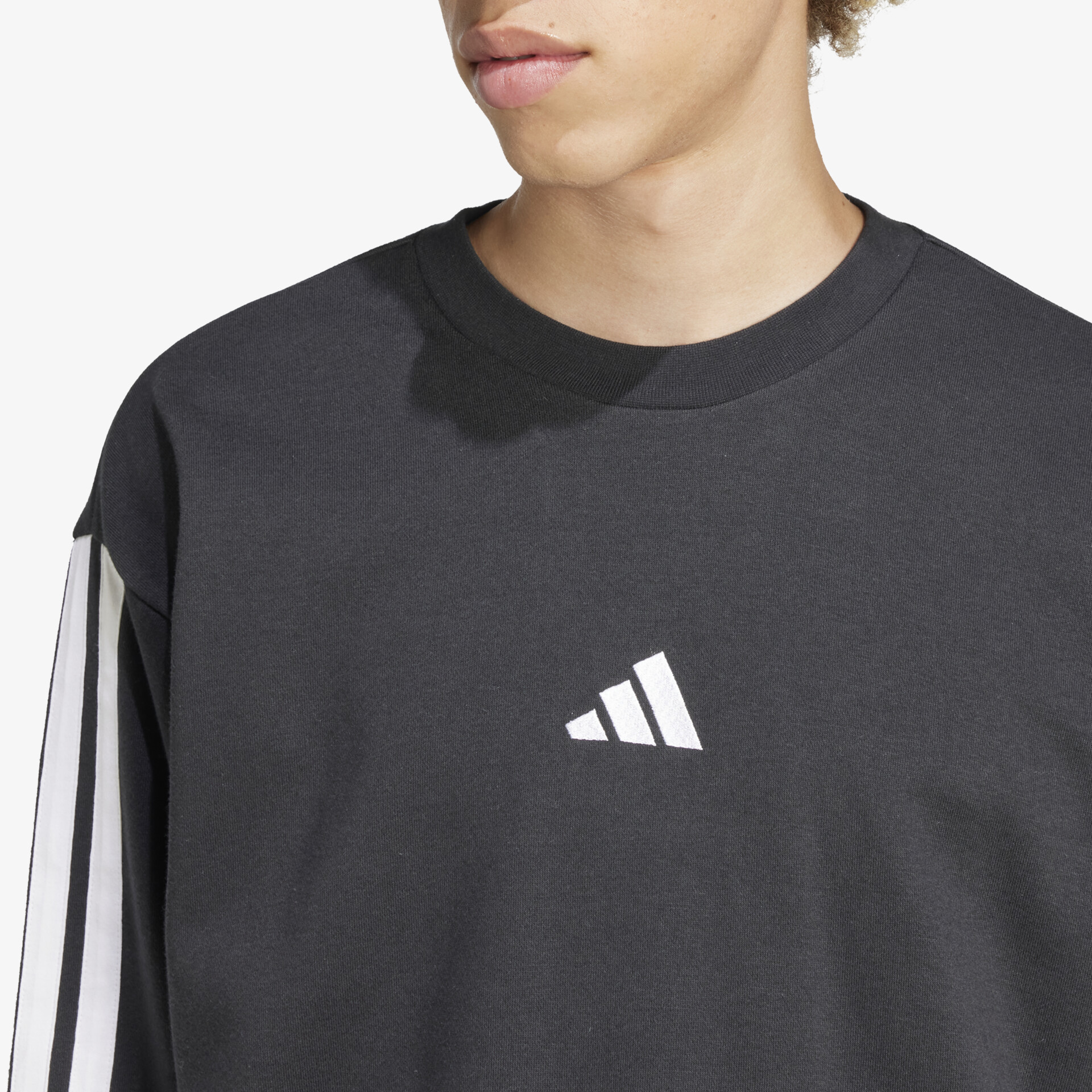 Detailaufnahme schwarzes Sweatshirt mit weißem Adidas-Logo, weicher Stoff und bequemer Schnitt