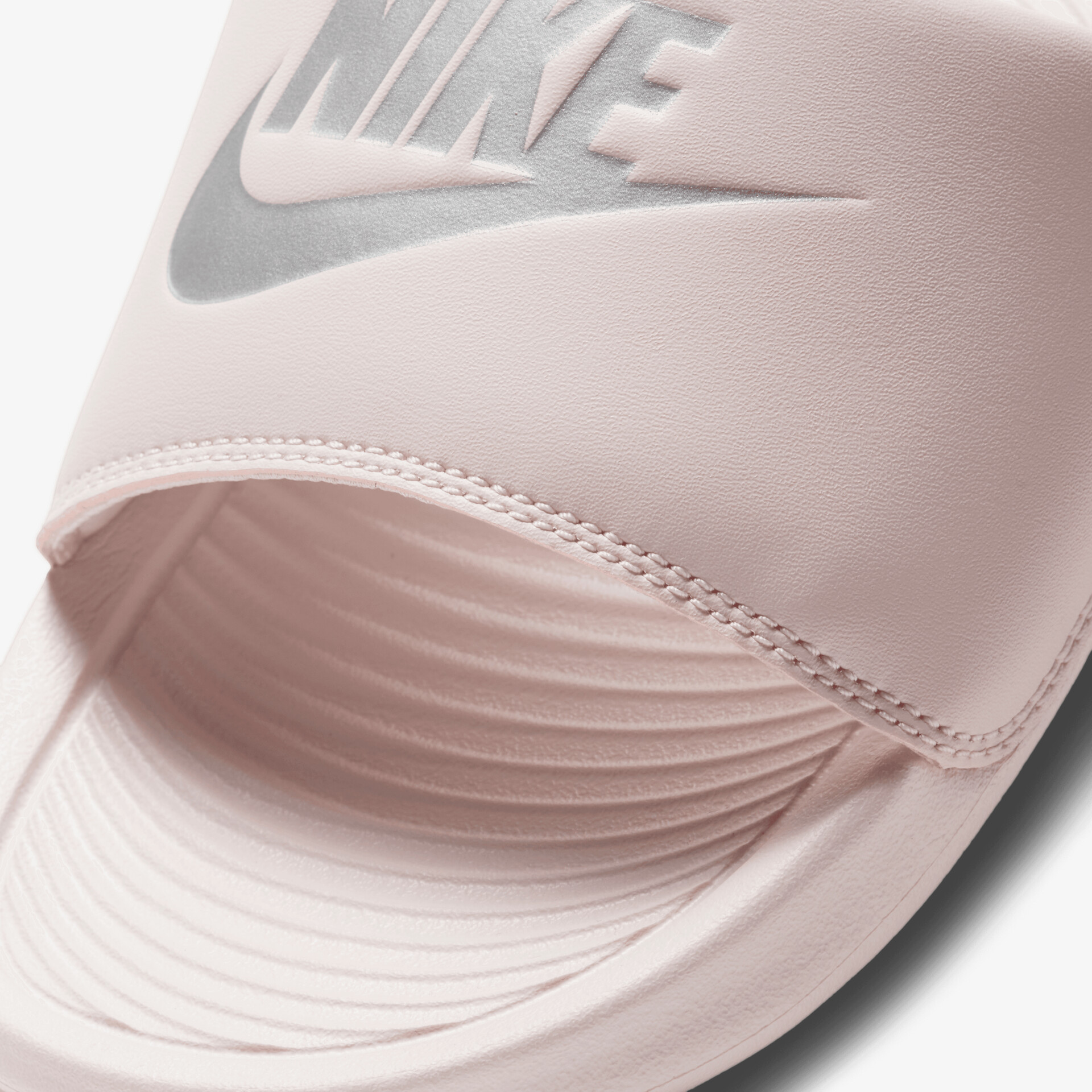 Detailaufnahme eines pinkfarbenen Nike Badelatschens mit gepolstertem Riemen und rutschfester Sohle in hoher Qualität