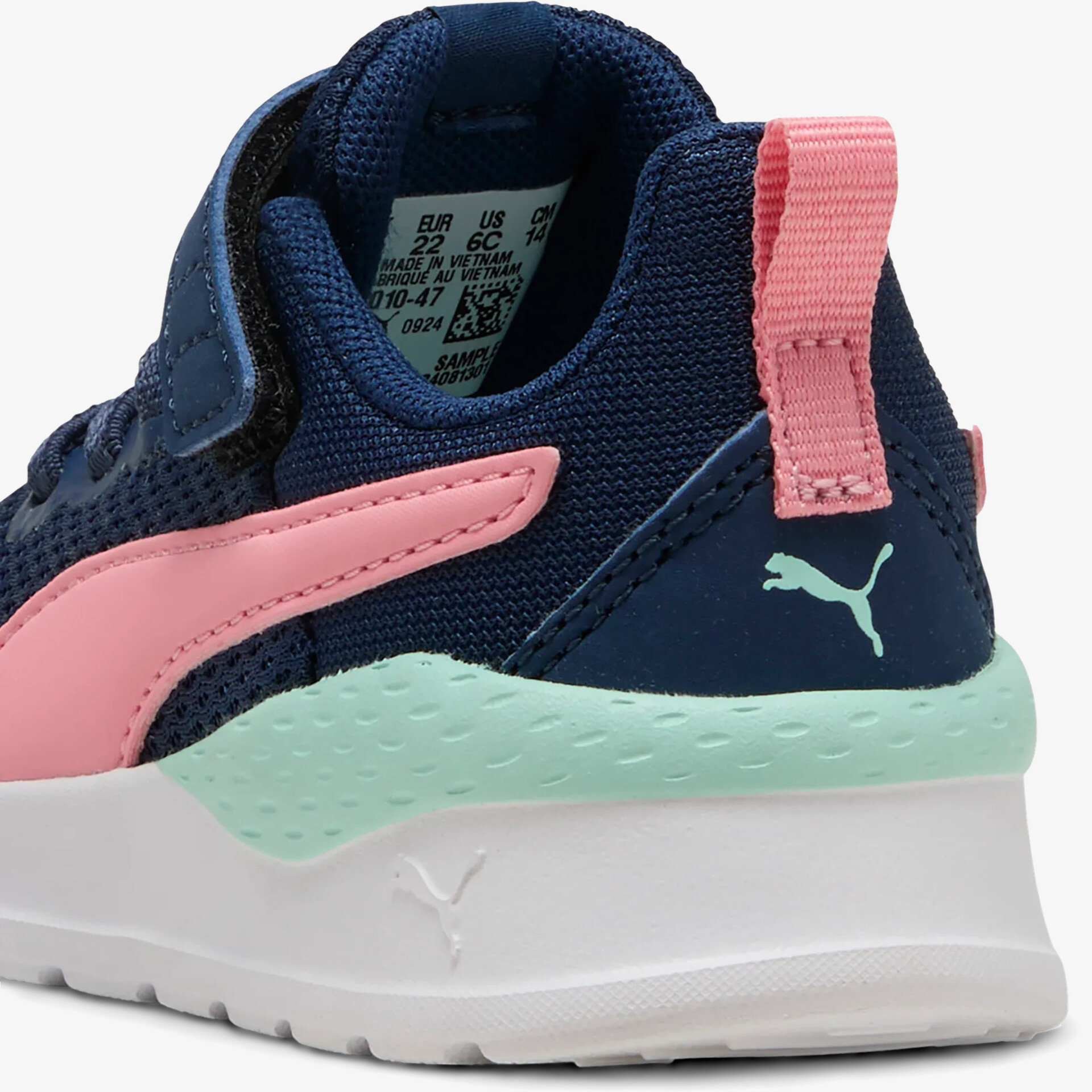 Detailaufnahme von atmungsaktivem, navyblauem Sneaker mit rosa Akzenten und robuster Sohle