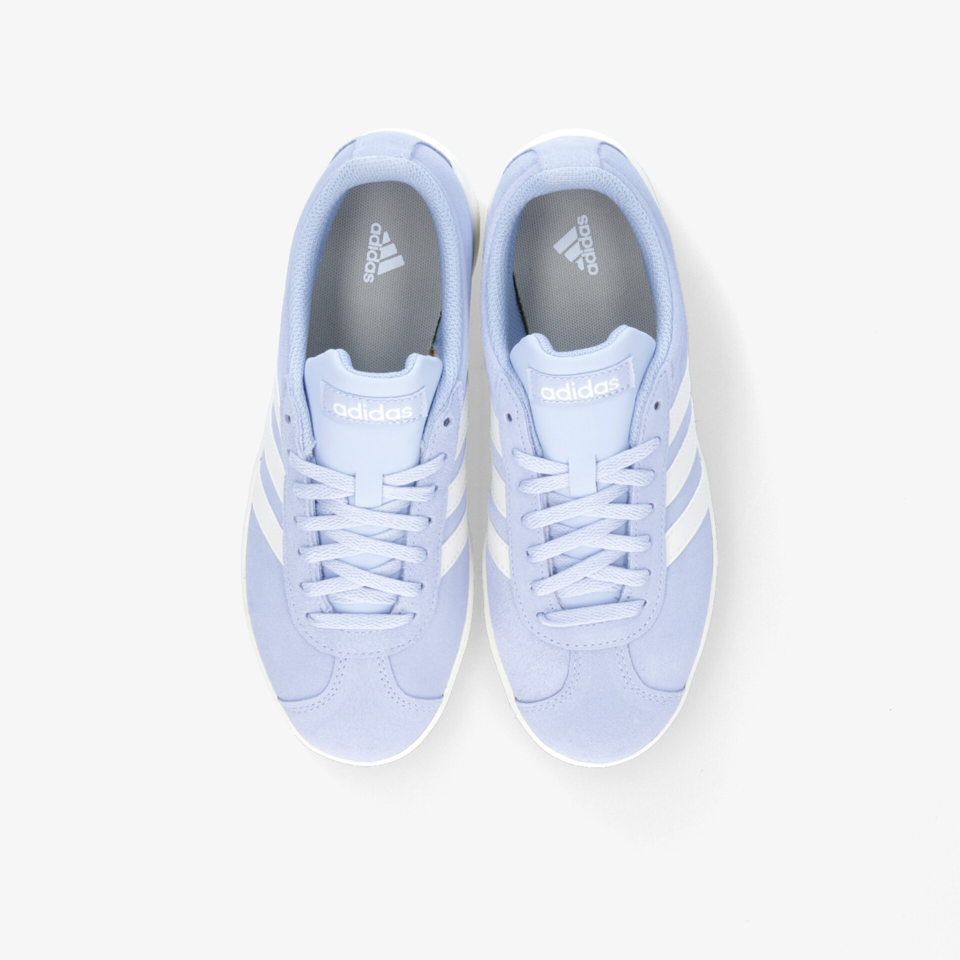 Obenansicht stilvoller, weißer Sportschuhe mit ikonischen Streifen und bequemer Passform.