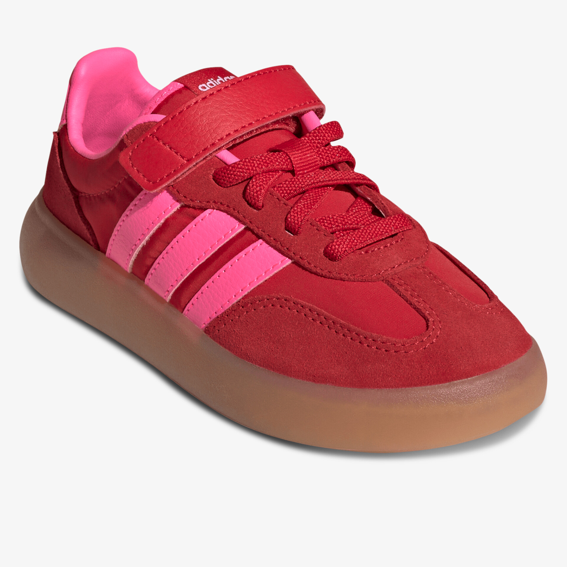 Roter Sneaker mit pinken Streifen und brauner Sohle in schräger Frontansicht