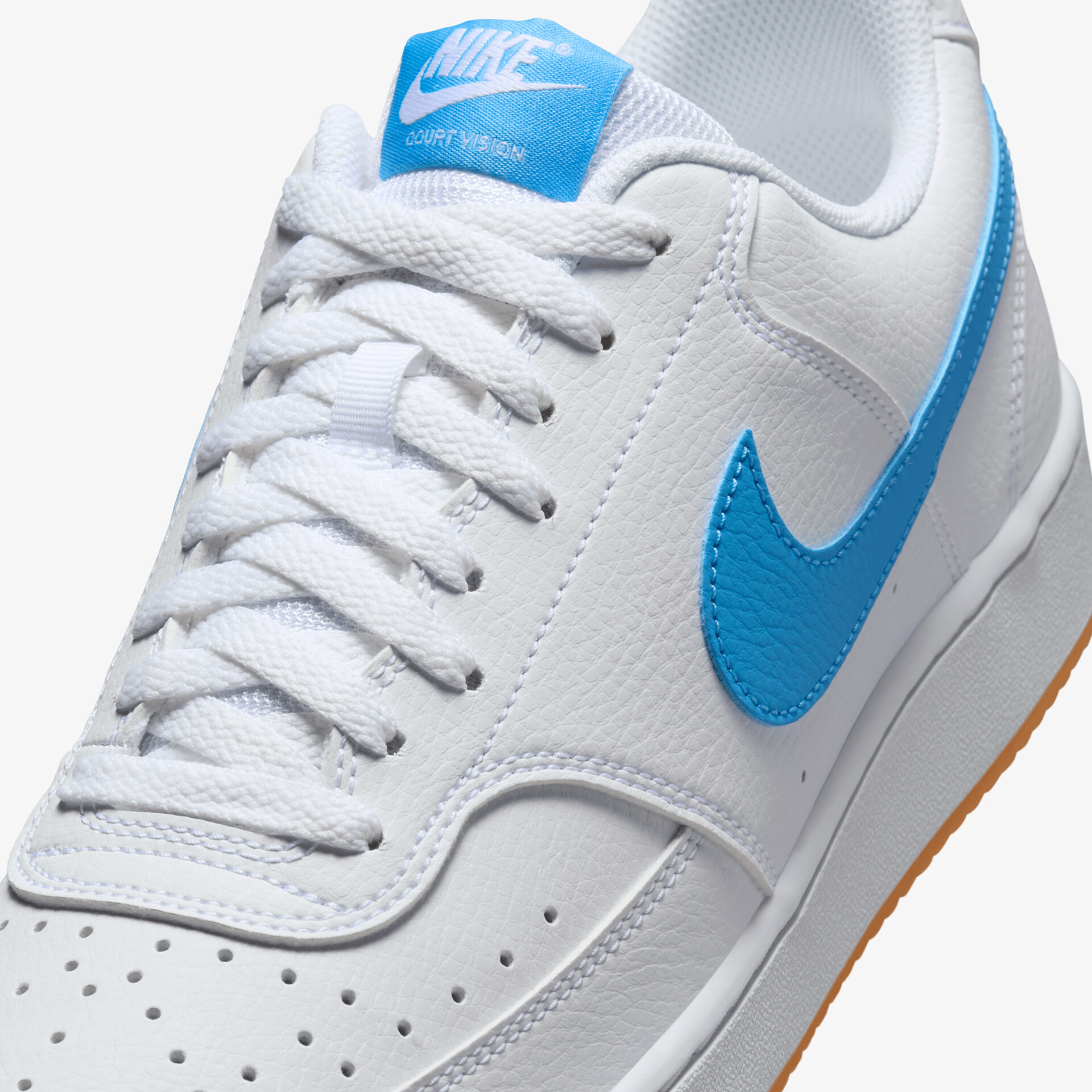 Detailaufnahme weißer Sneaker mit blauem Nike-Logo und fein gearbeiteter Schnürung aus hochwertigem Material