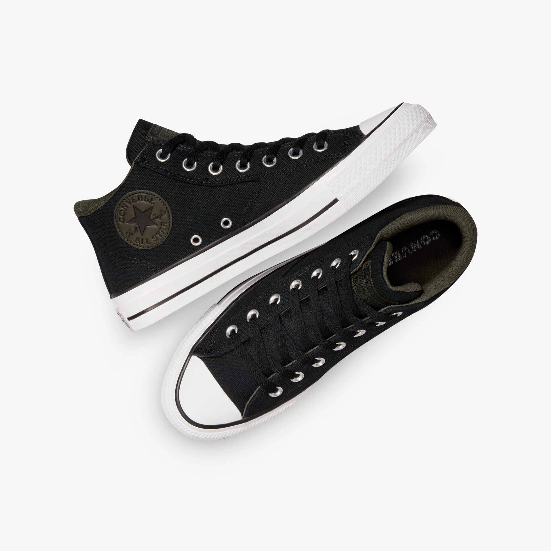 Schwarze klassische Canvas Sneakers mit weißer Gummisohle und runder Zehenkappe, liegend auf weißem Hintergrund