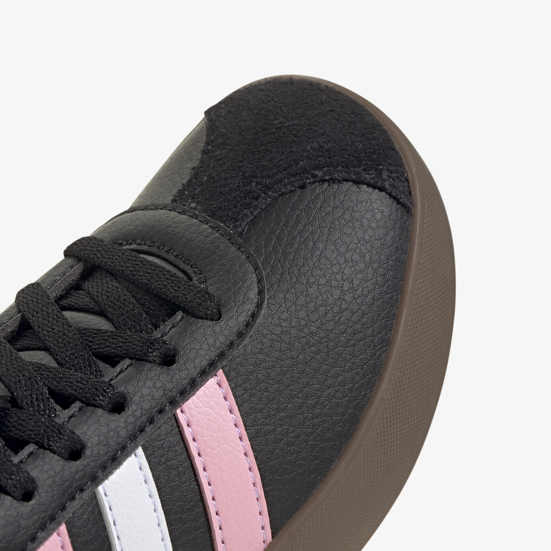Detailaufnahme eines schwarzen Sportschuhs mit rosa und weißen Streifen, hochwertige Schnürung und strapazierfähiges Material