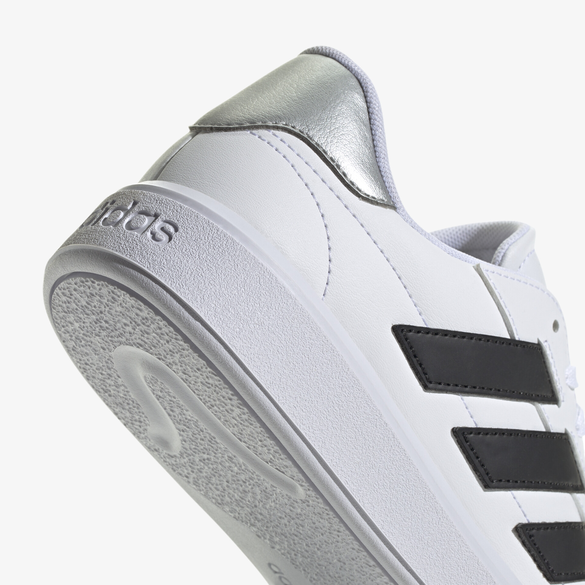 Moderner weißer Sneaker mit schwarzem Streifen und silbernem Detail für einen sportlich eleganten Look.