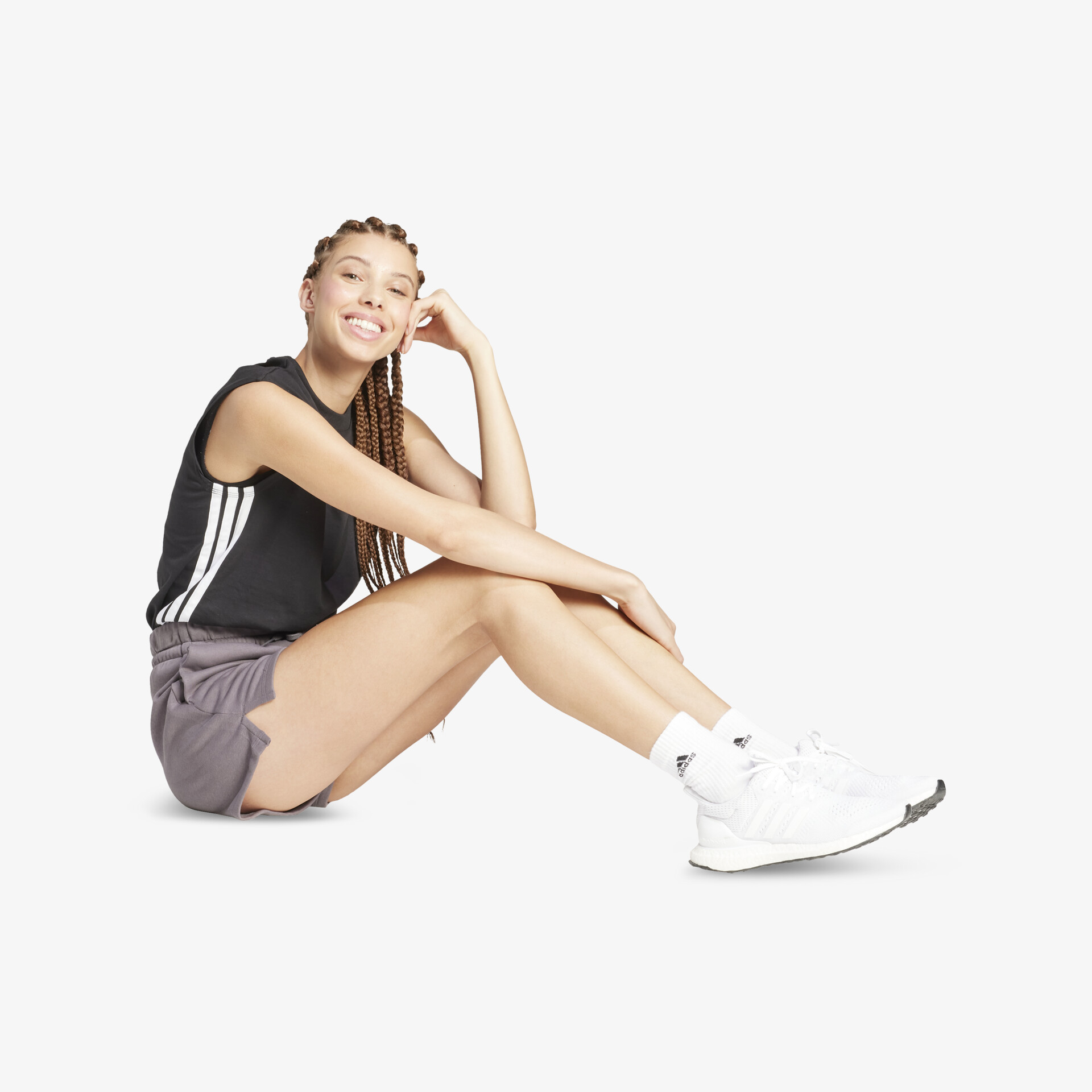 Person sitzt lächelnd mit weißen, leichten und bequemen Sneakers, die sportlich und modern wirken