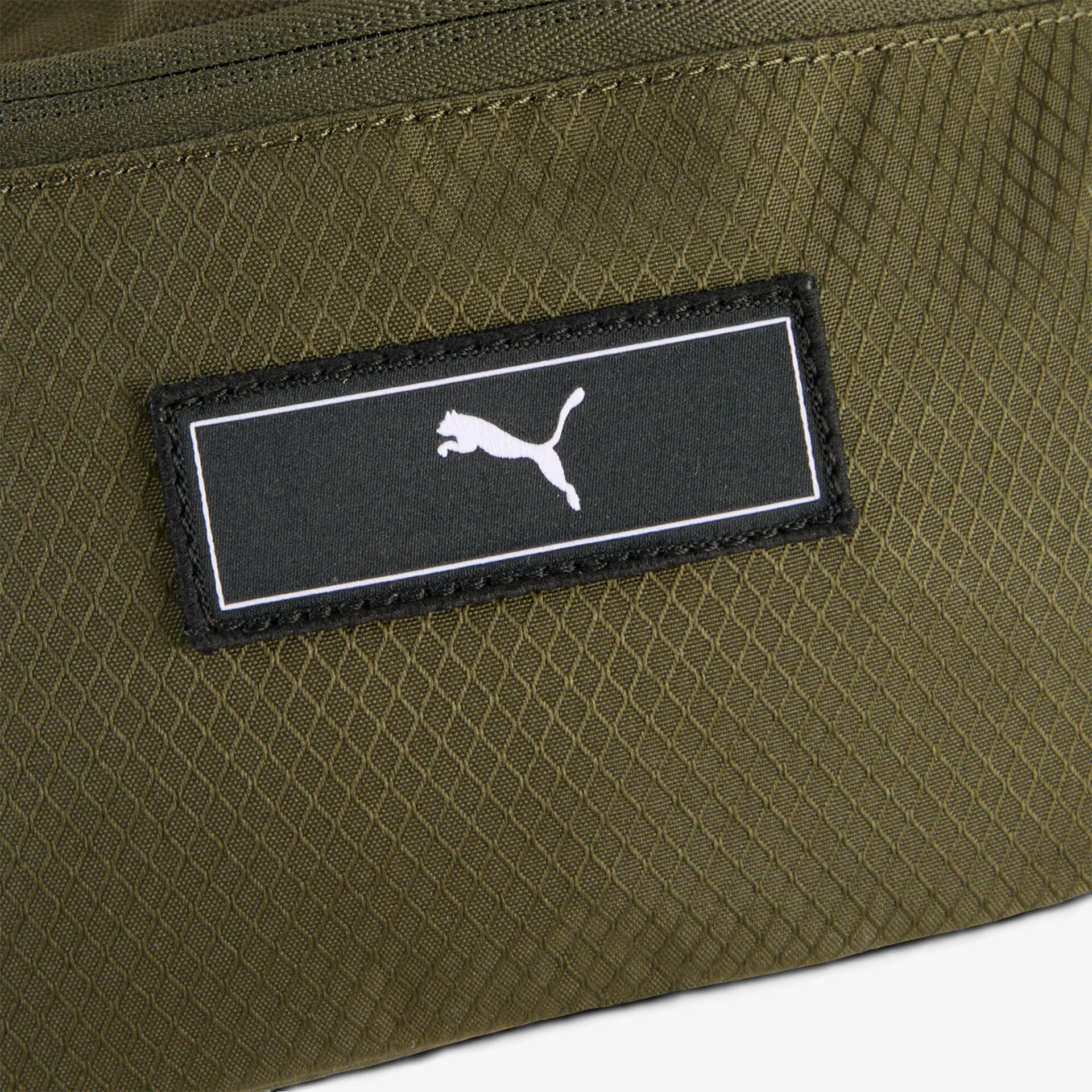 Detailaufnahme eines robusten grünen Textilmaterials mit auffälligem weißen Puma Logo