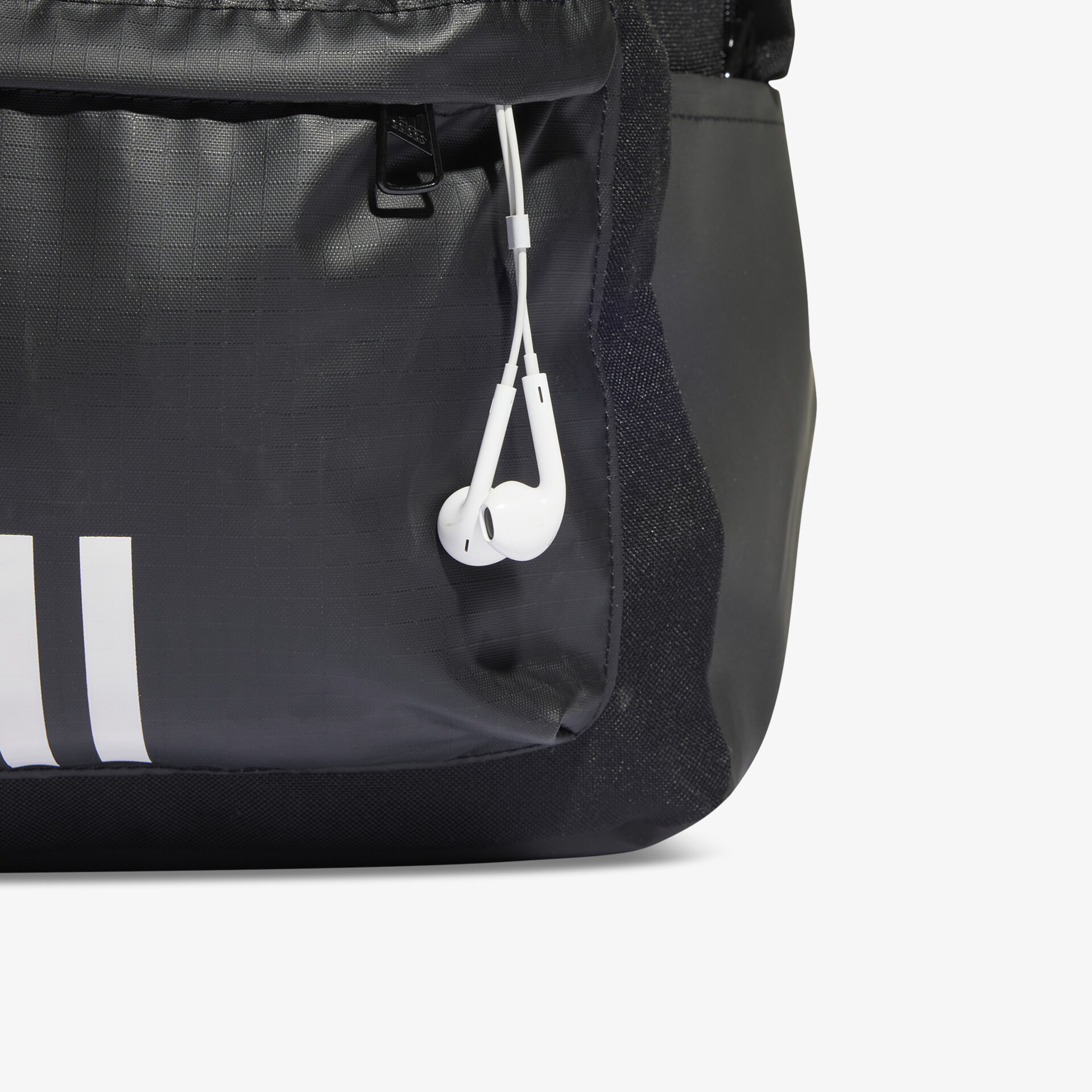 Detailansicht eines schwarzen Rucksacks mit Kopfhörern in der Außentasche, robustes und funktionales Material