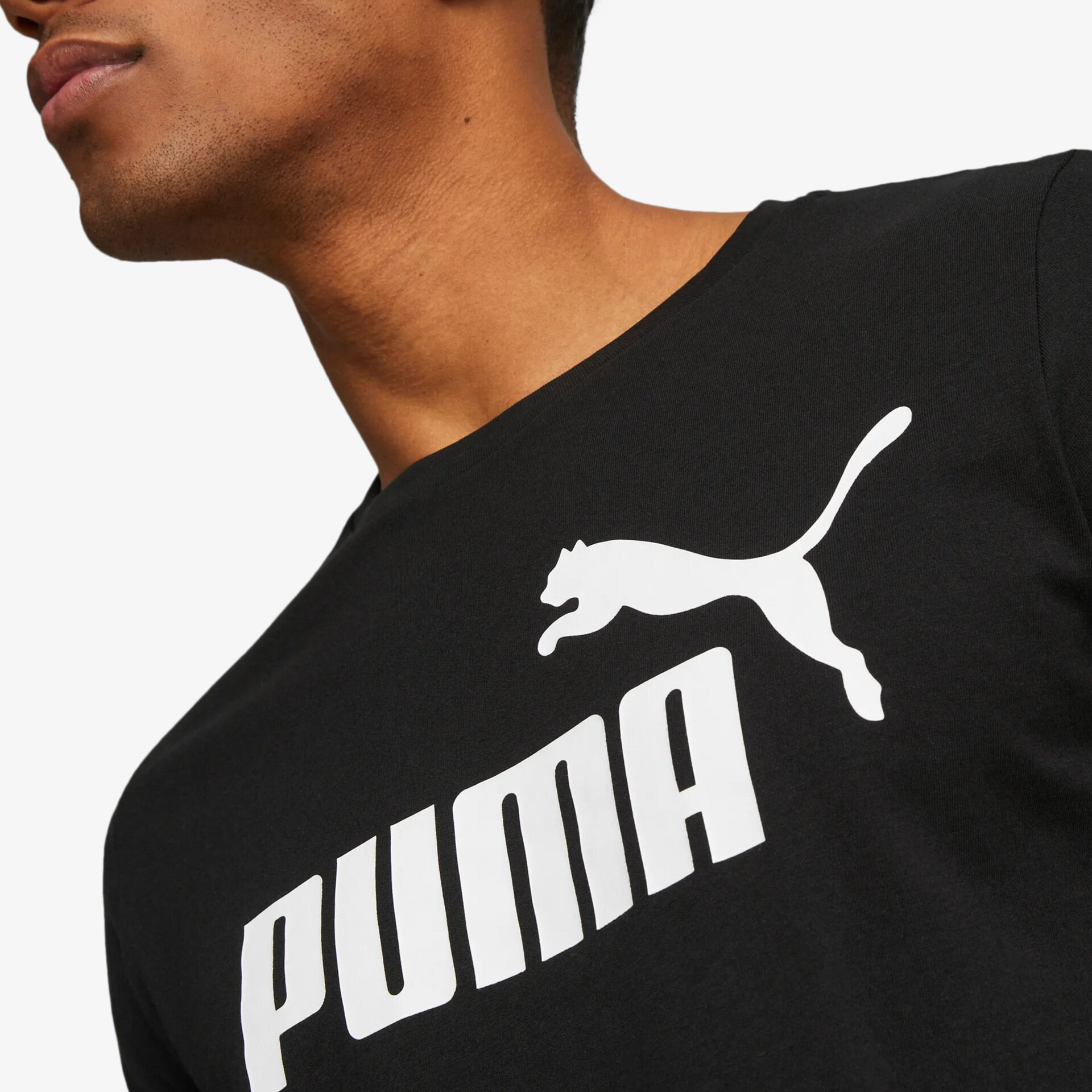 Detailaufnahme eines schwarzen Puma T-Shirts mit klar erkennbaren, weißen Markenlogo und hochwertigem Material