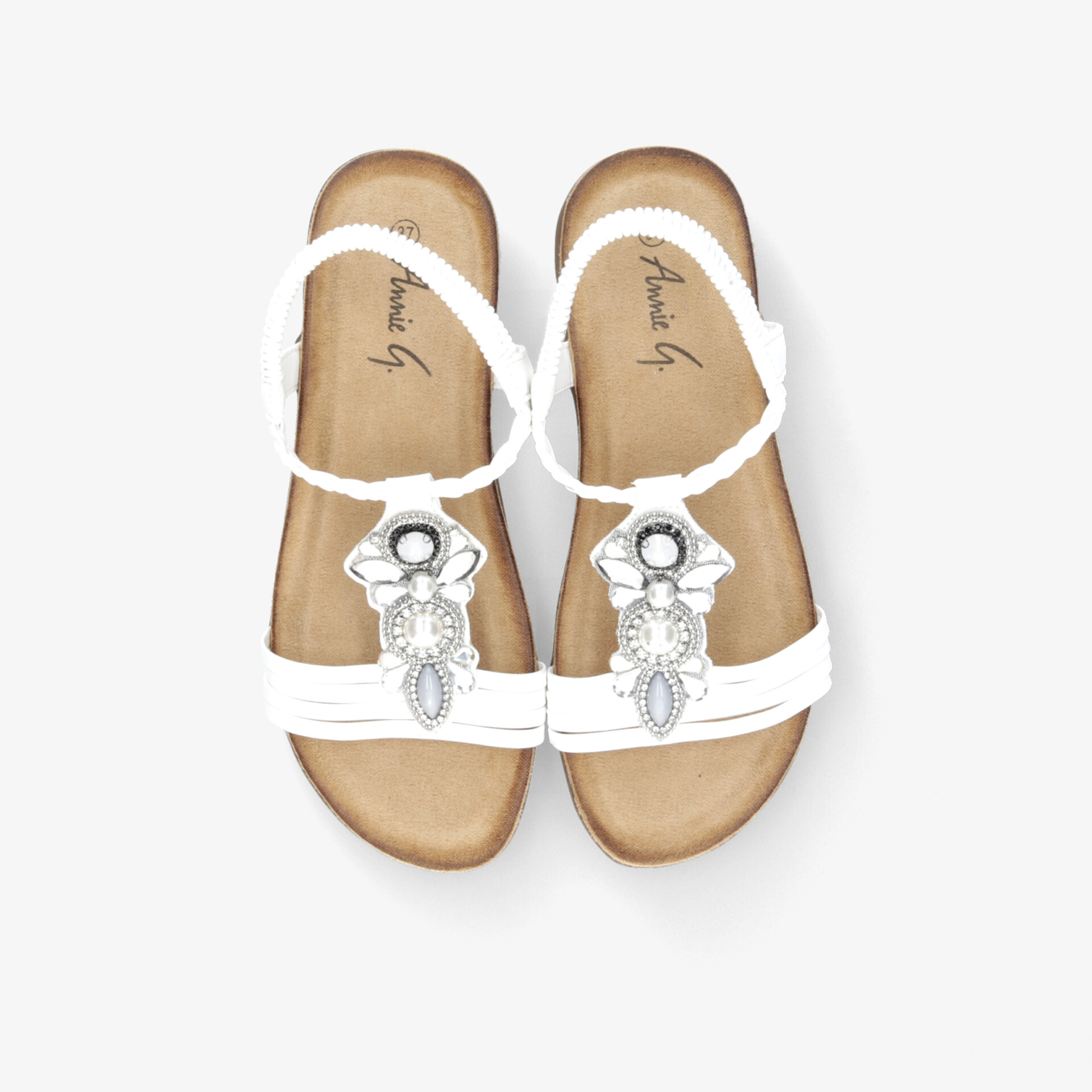 Schickes Paar weiße Sandalen mit dekorativer Verzierung und bequemer flacher Sohle für sommerlichen Komfort