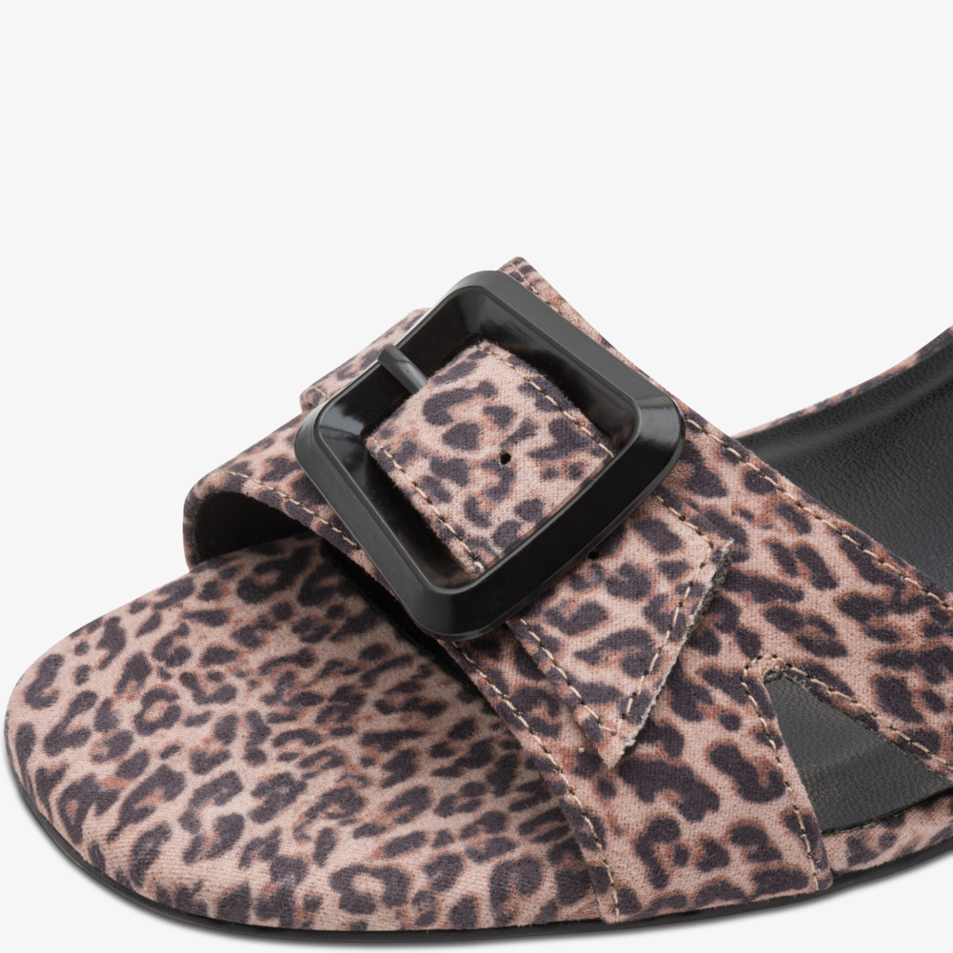 Detailaufnahme eines modischen Schuhs mit großem schwarzem Schnallenverschluss und Leopardenmuster