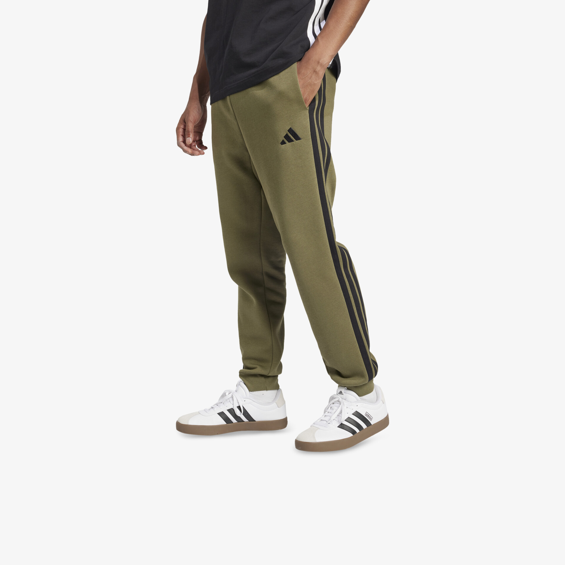 Sportlicher weißer Adidas Sneaker kombiniert mit olivgrüner Jogginghose, bequem und modern für Alltag und Freizeit.