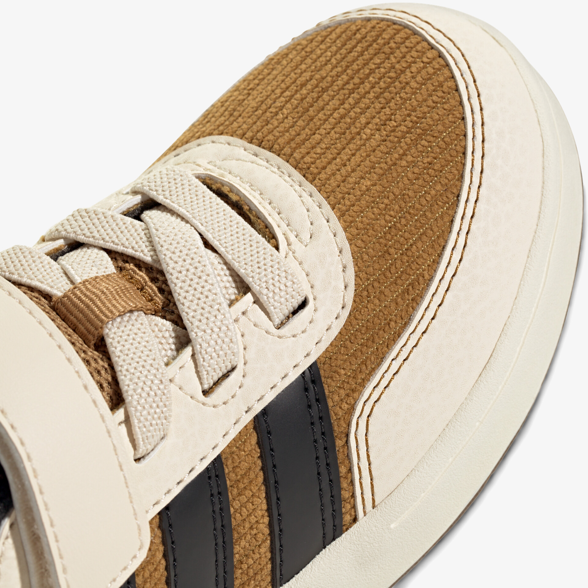 Detailaufnahme eines braunen und beigen Sportschuhs mit Stoffoberfläche und Schnürsenkeln