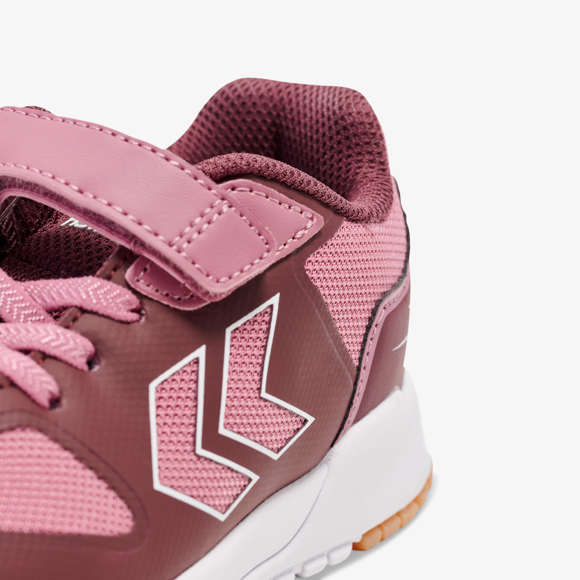 Moderner Sportschuh mit Klettverschluss und atmungsaktivem Material in trendigen Rottönen.