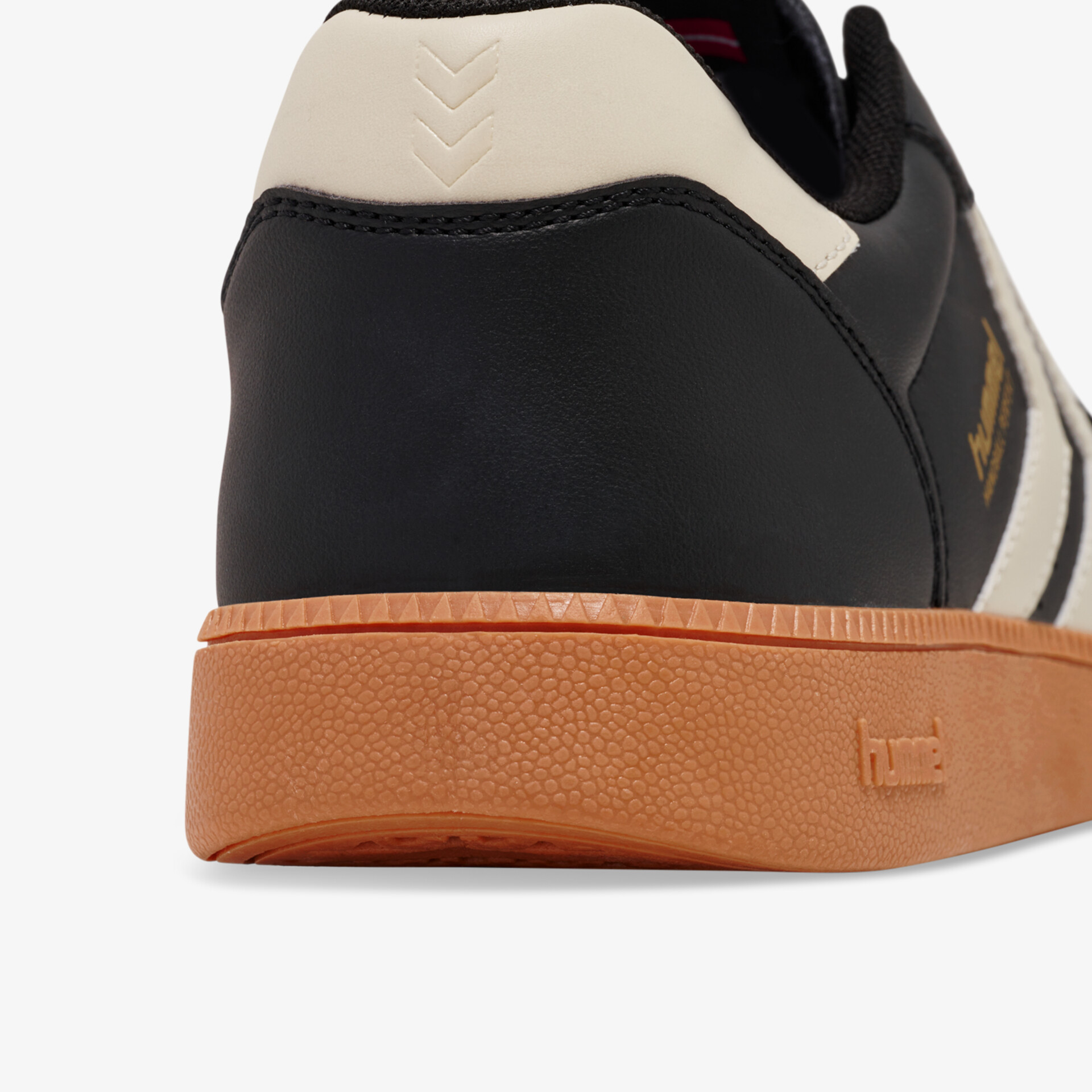 Schuhrückansicht mit robustem schwarzem Obermaterial und beige Akzenten samt langlebiger brauner Gummisohle