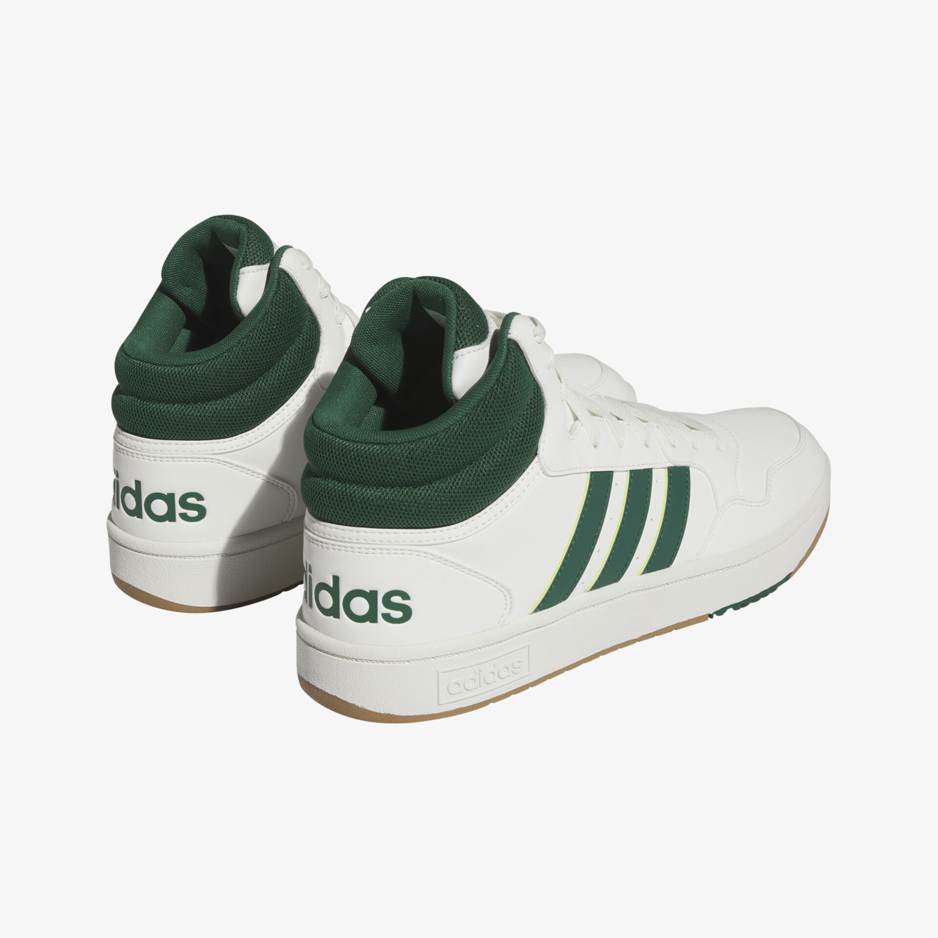 Weiße Turnschuhe mit grünen Details und markantem Logo an der Hacke für modischen Komfort.