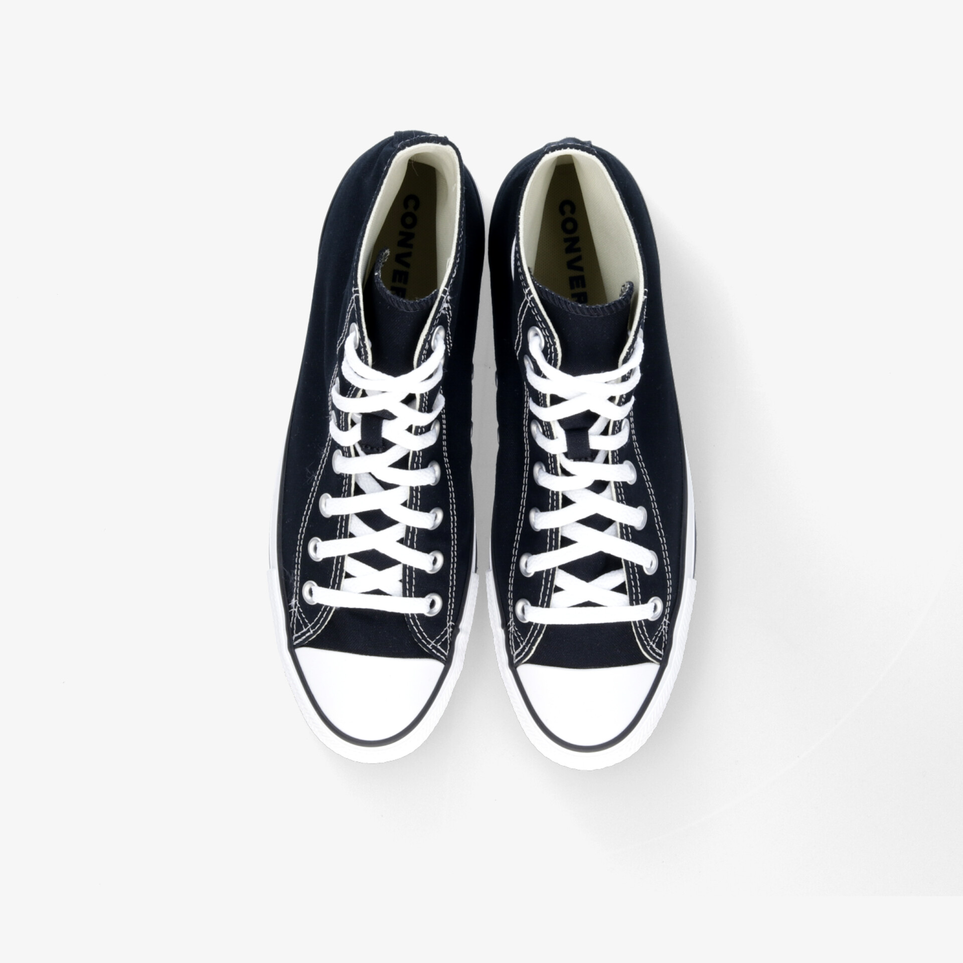 Klassische schwarze Sneaker mit weißer Kappe und Schnürung, ideal für Alltag und Freizeit.