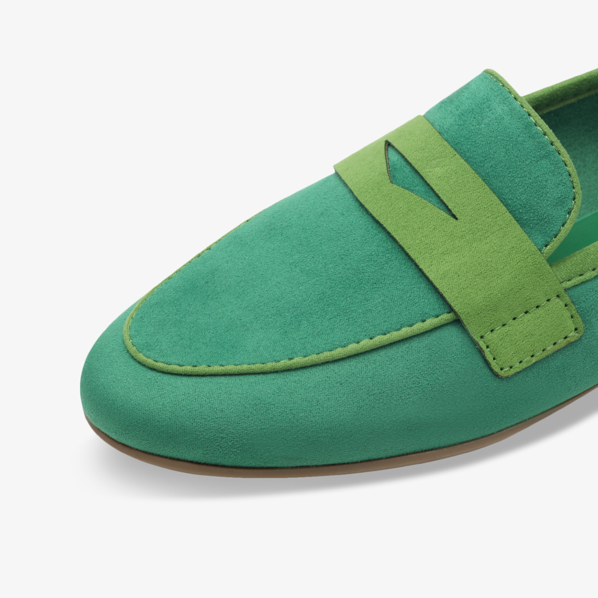 Detailaufnahme eines grünen Loafers mit feiner Naht und hochwertigem, weichem Material