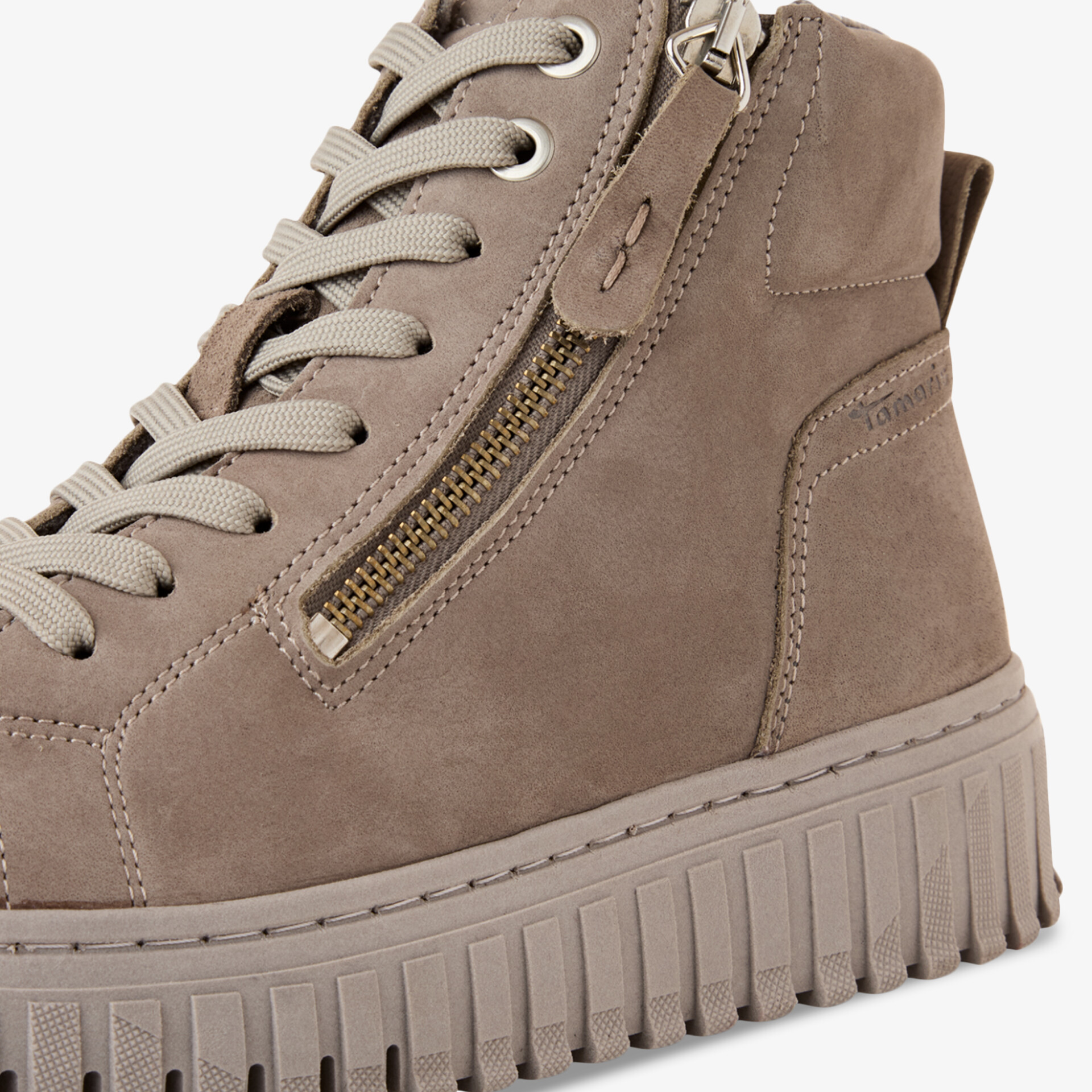 Detailansicht eines beigen Nubuk Sneakers mit Reißverschluss und profilierter Sohle für hohen Tragekomfort