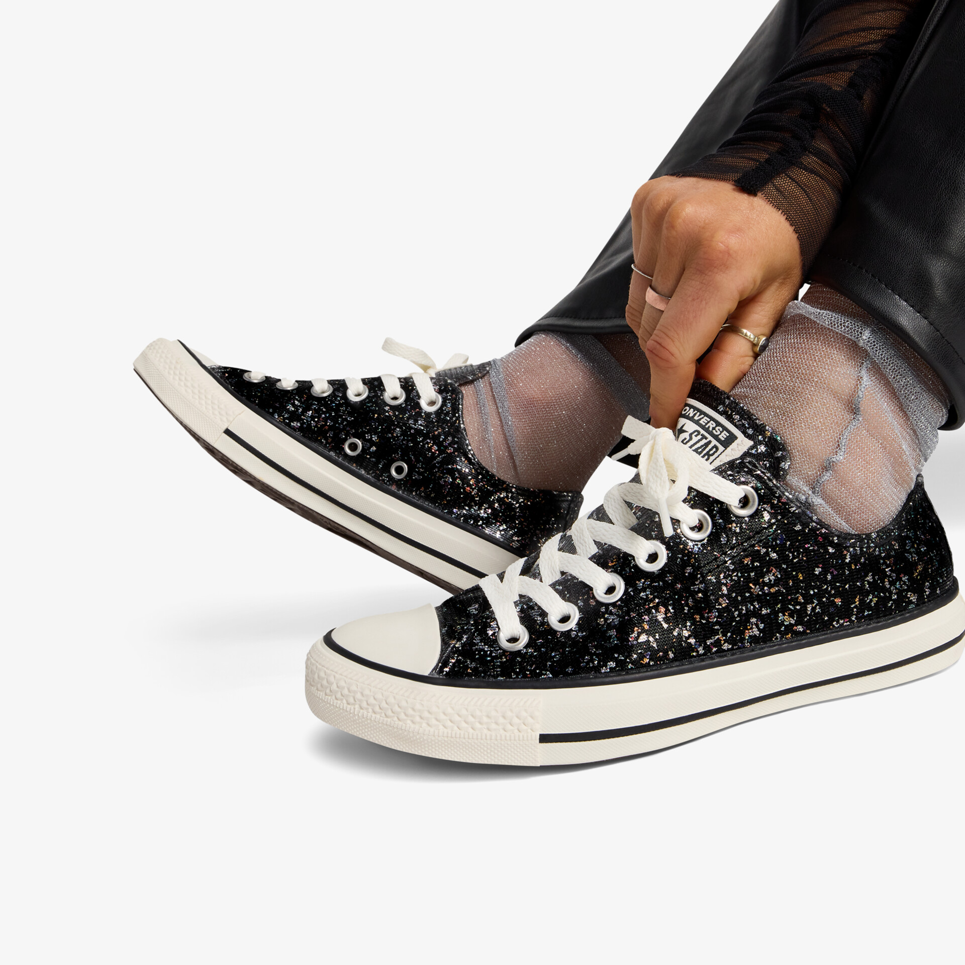 Modische glitzernde Sneaker mit bequemer Passform und weißen Schnürsenkeln, getragen am Fuß