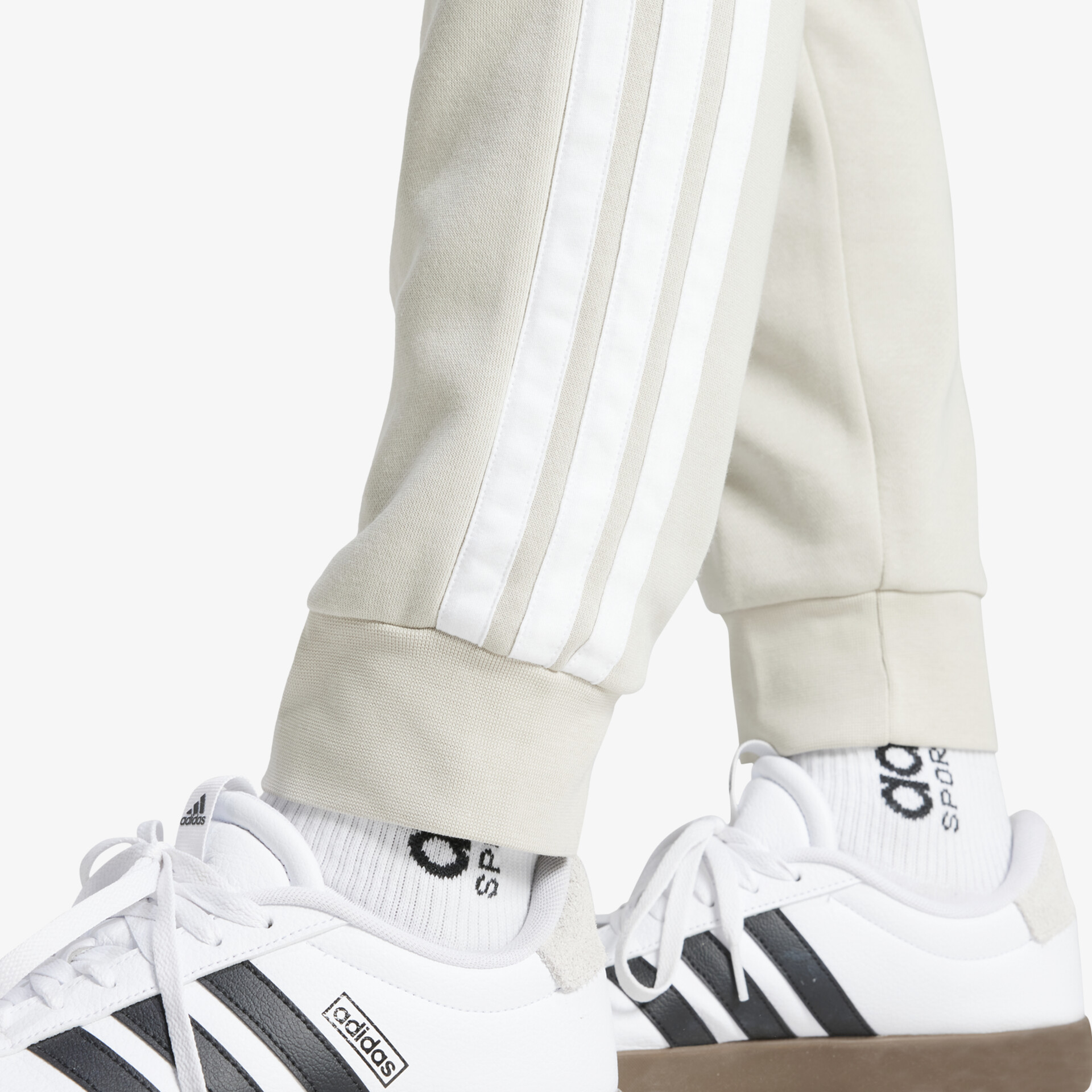 Weiße Sneaker mit schwarzen adidas Streifen, sportliches Design und bequeme Passform seitlich getragen